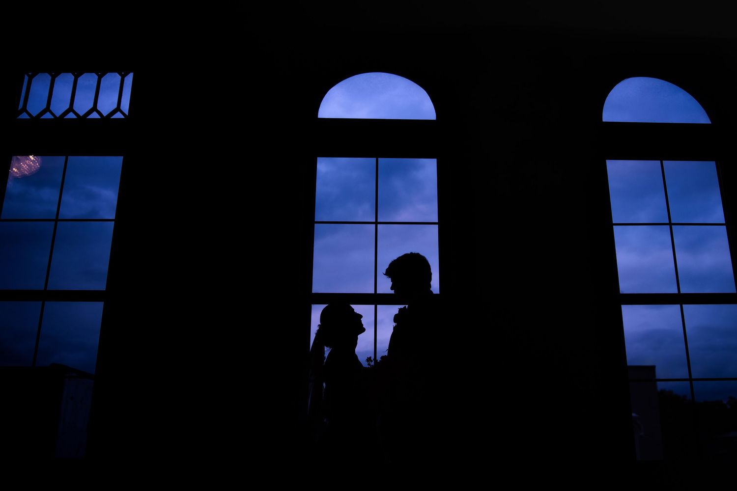 A series of dark windows against a night sky showing the moon in different phases and positions.