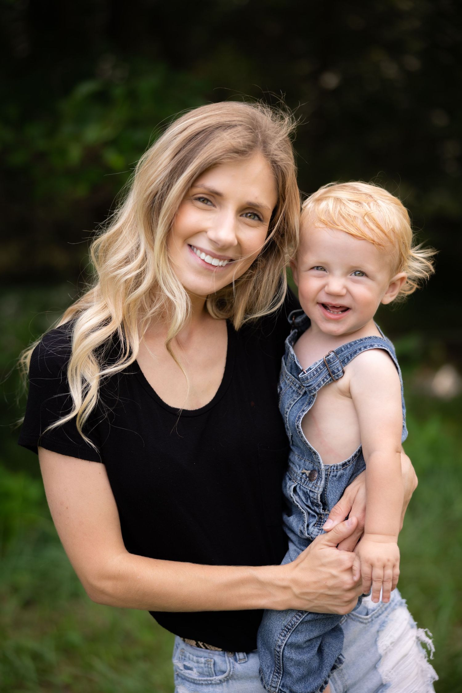 Playful moments captured between parent and child in outdoor portrait session.