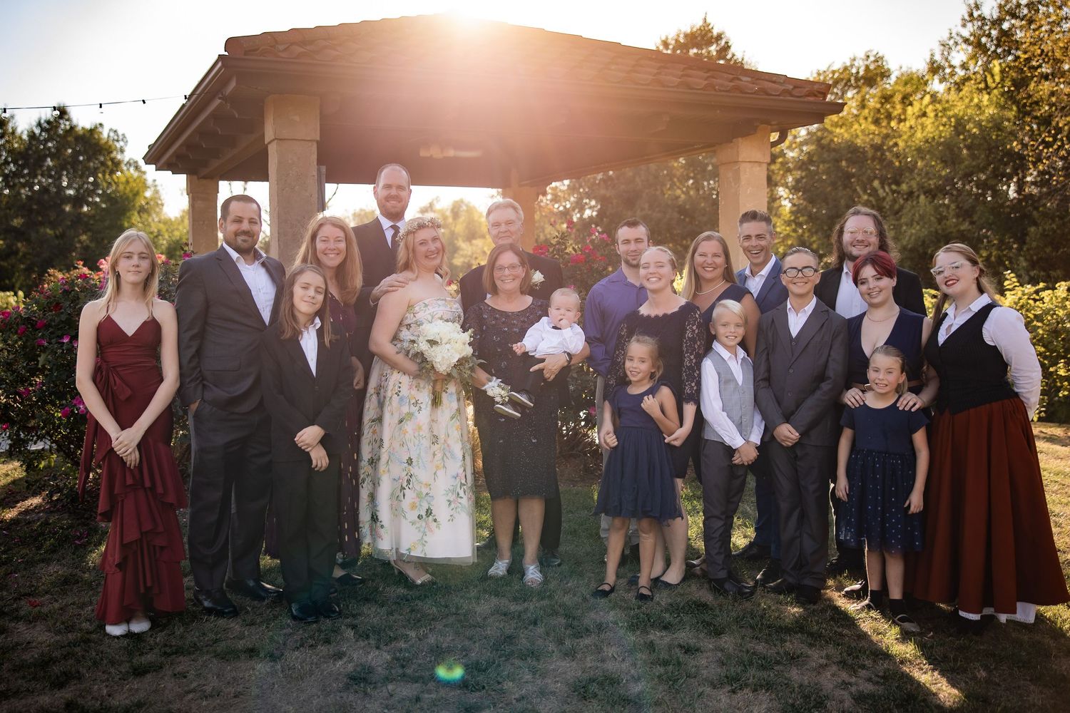 Wedding party group photos taken at sunset with warm golden lighting outdoors.