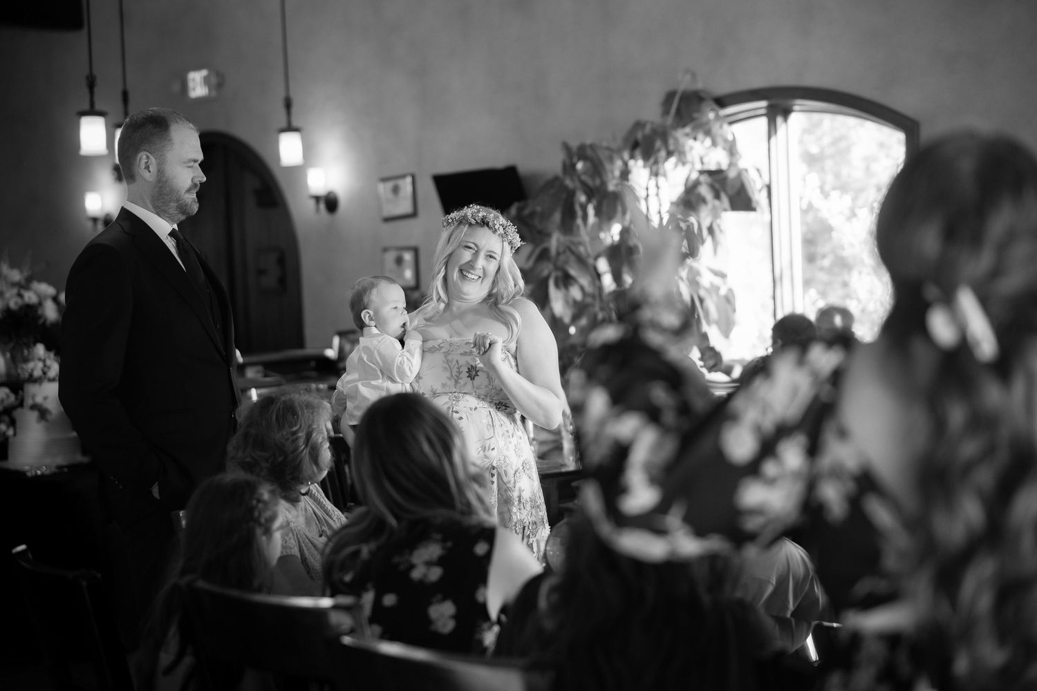 Black and white photos capturing wedding reception moments with guests dancing and celebrating in a dimly lit venue.