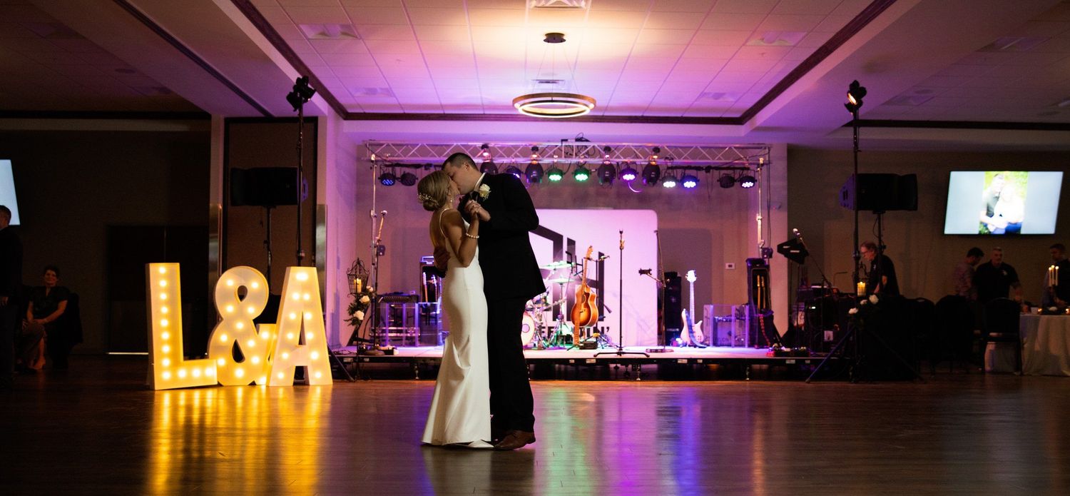 Wedding reception ballroom decorated with dramatic purple and gold lighting.