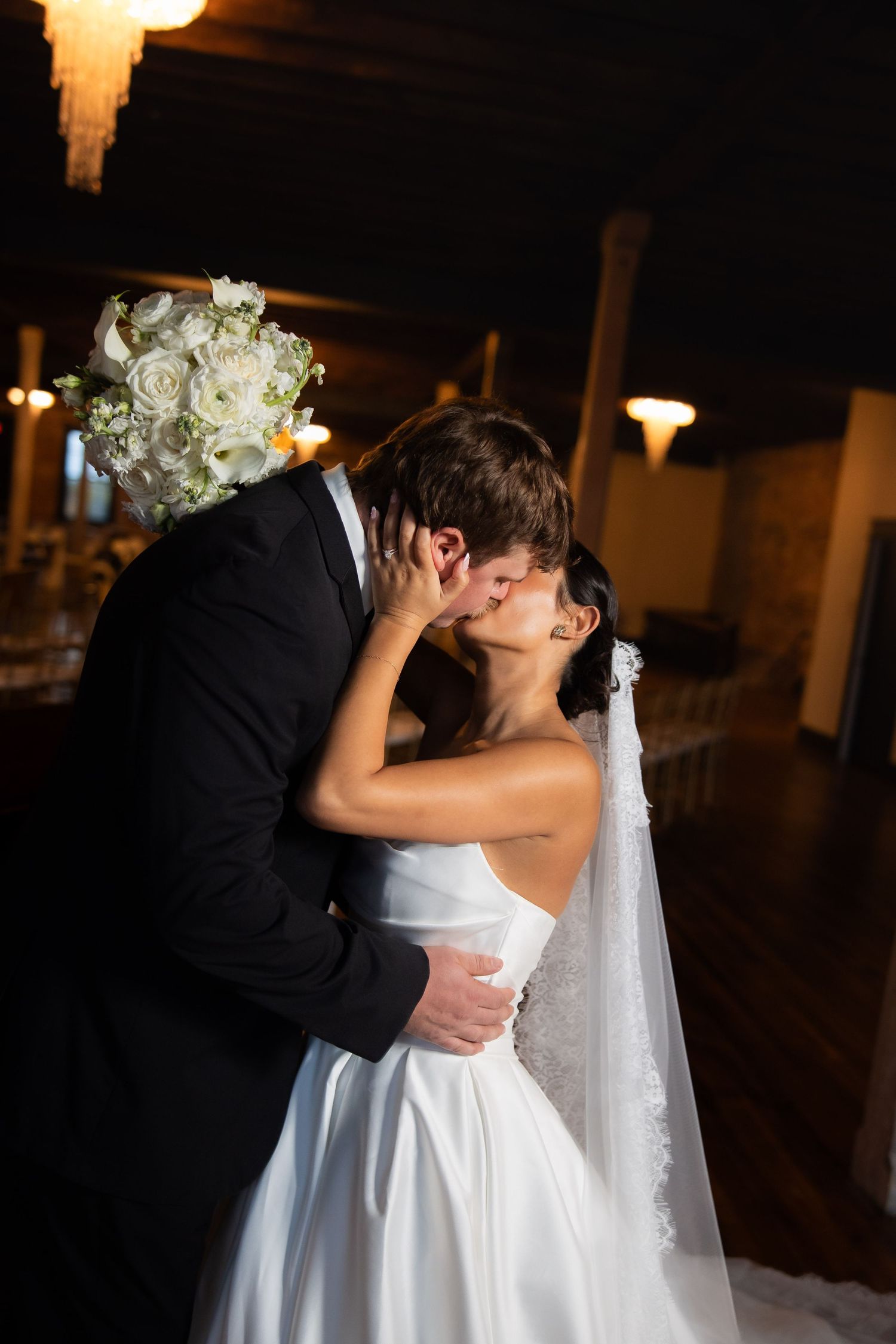 Romantic first kiss between newlyweds at wedding ceremony.