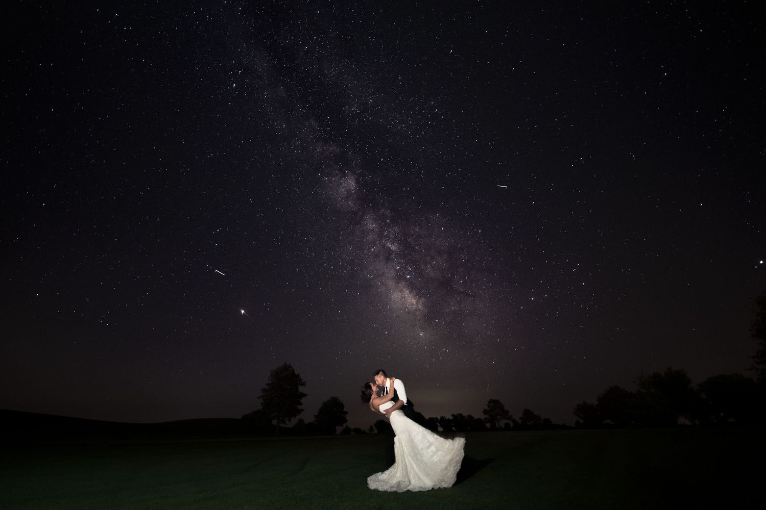 Starry night sky creates romantic backdrop for wedding photography.