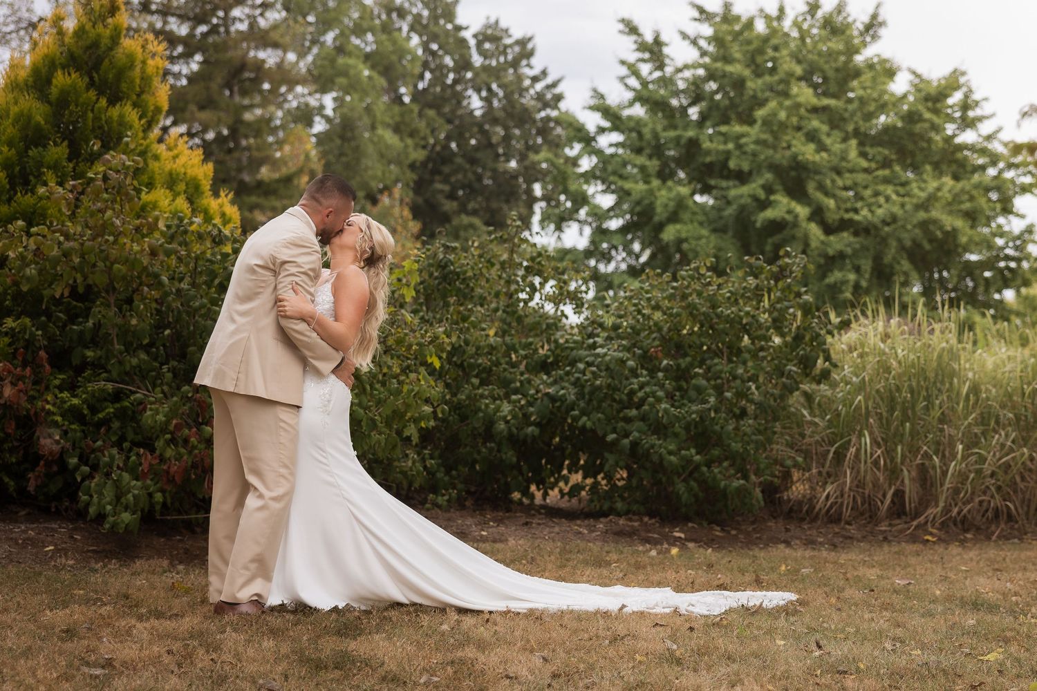 Scenic outdoor wedding portraits taken in a natural garden landscape during golden hour.