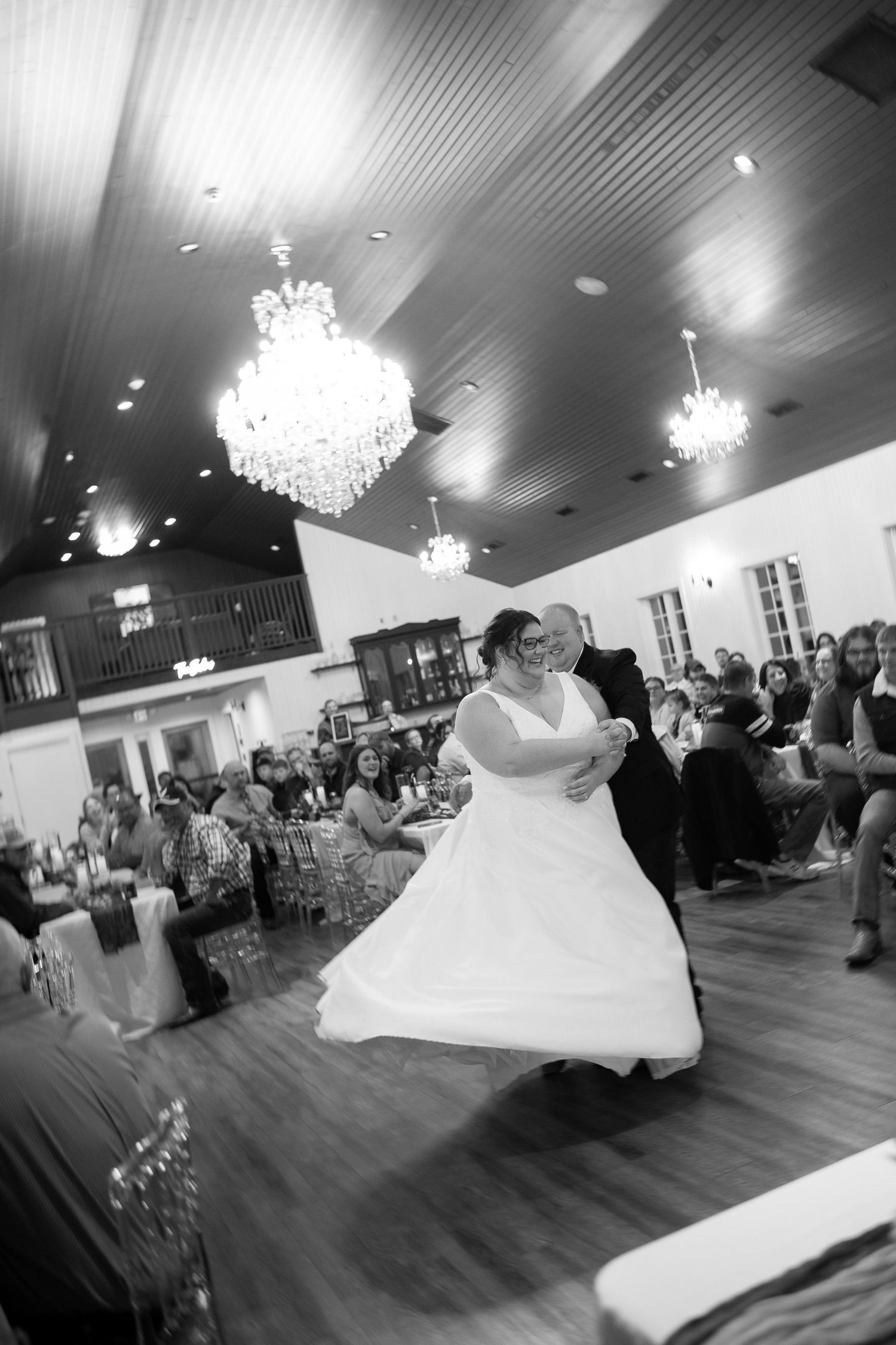 Black and white photos of a wedding reception dance floor with elegant chandeliers and flowing movement.