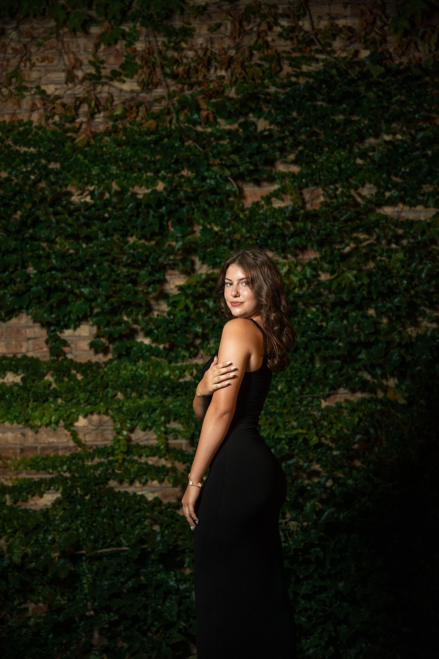 Artistic portrait sequence against an ivy-covered wall in dramatic lighting.