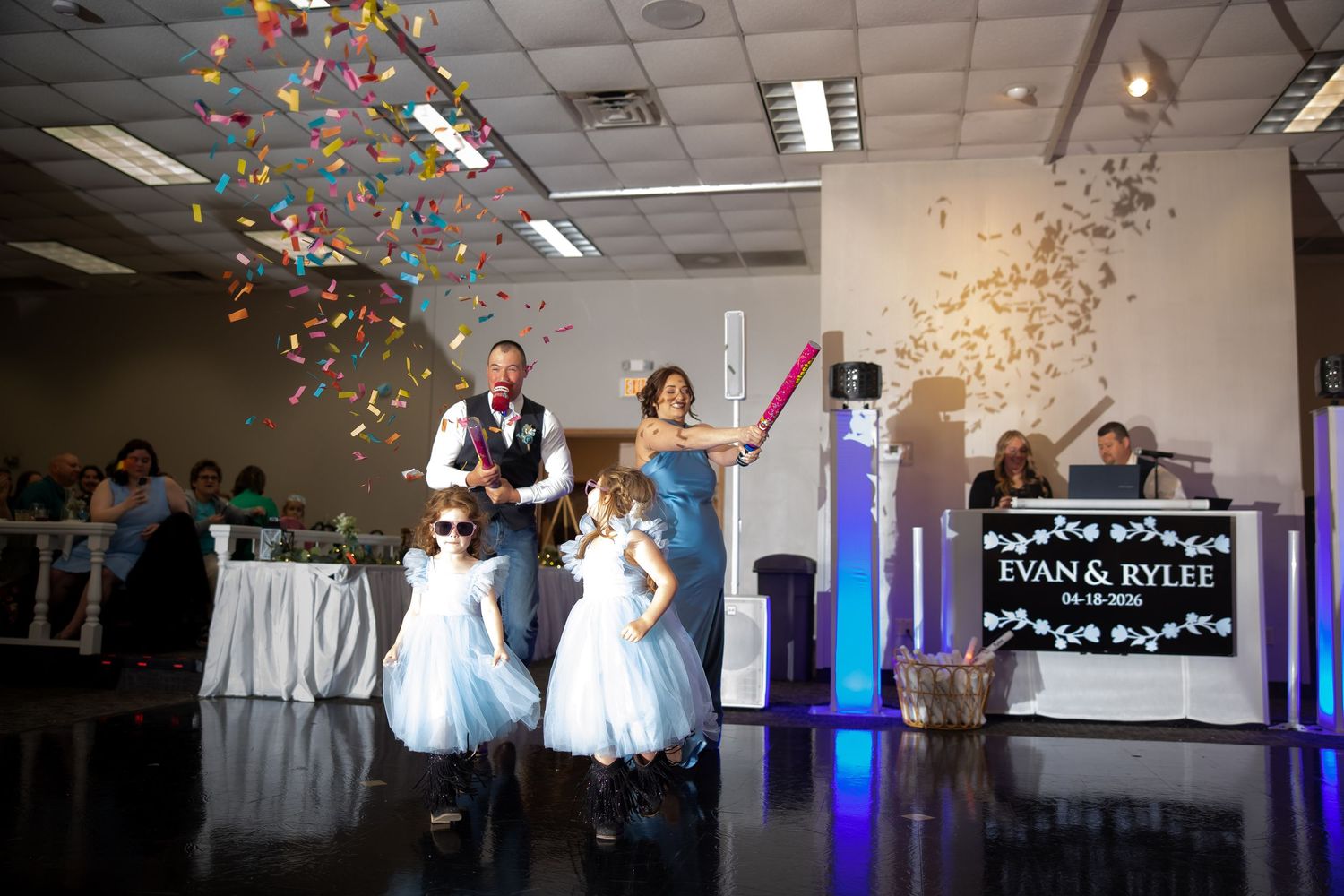 Evan and Rylee make a grand entrance with flower girls and colorful confetti cannons at their wedding reception.