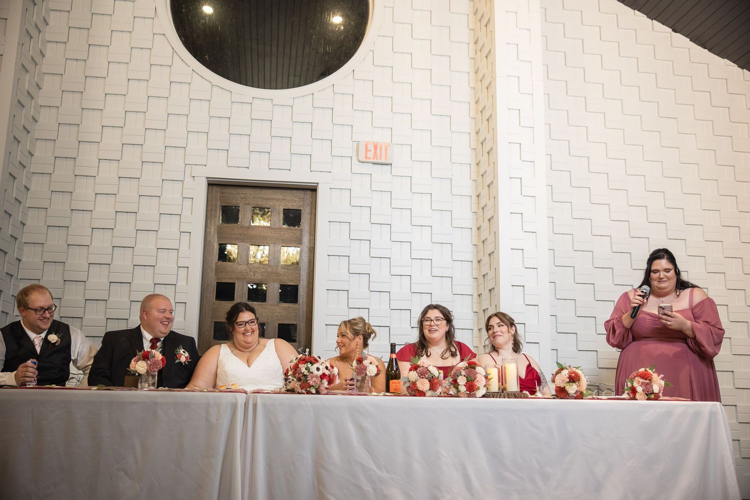 Wedding reception venue with white textured walls and elegant table settings.