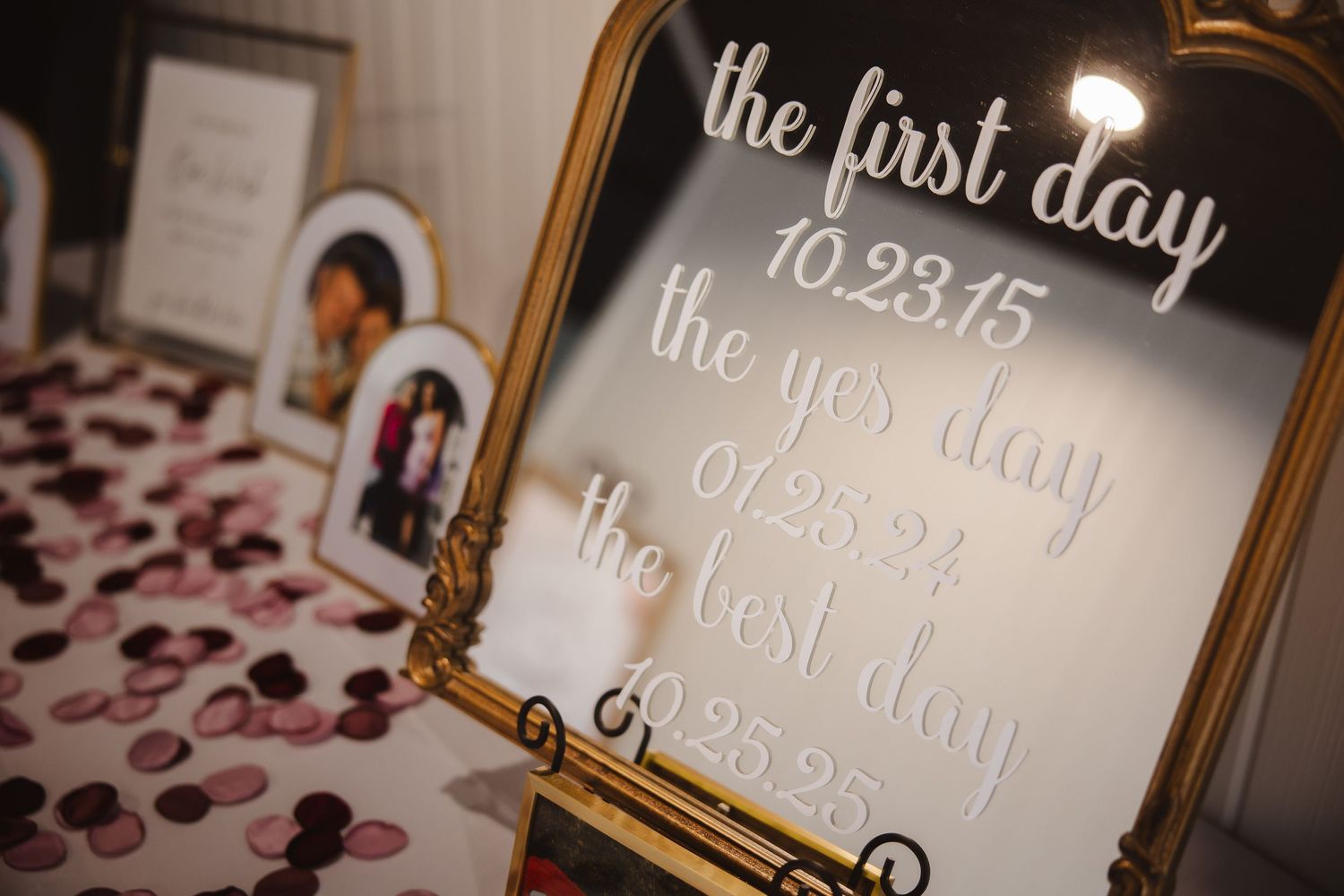 Gold framed mirror displays elegant white calligraphy text for a wedding date and message.
