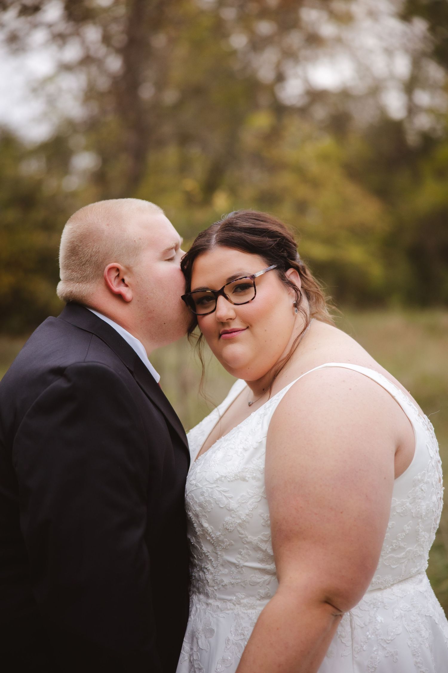 Intimate moment between newlyweds during autumn outdoor wedding photoshoot.