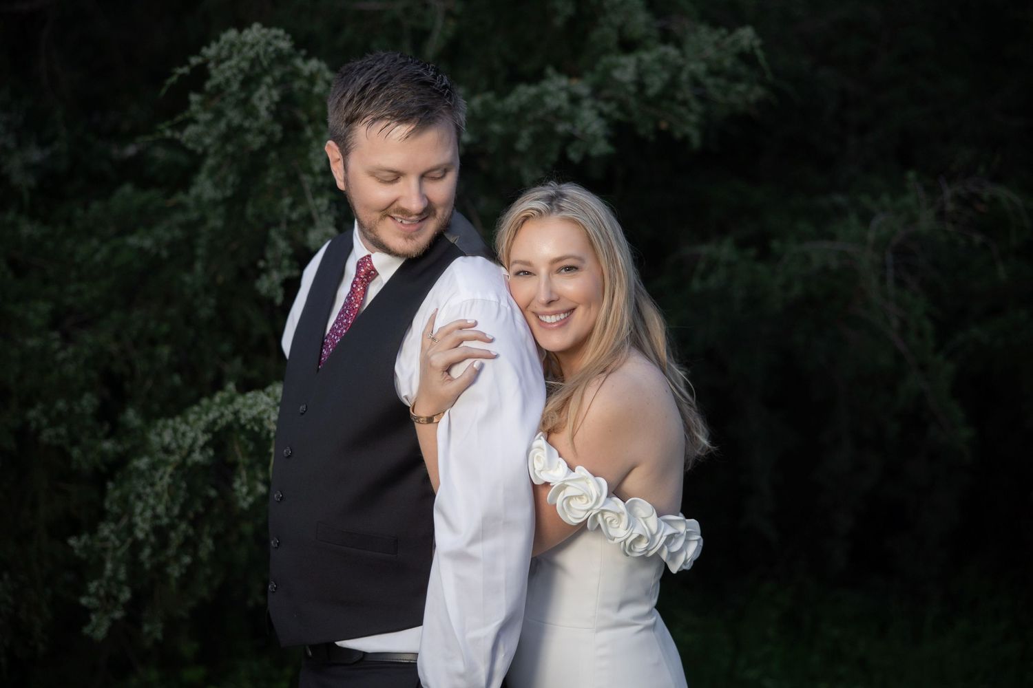 Romantic evening wedding portraits captured in garden setting.