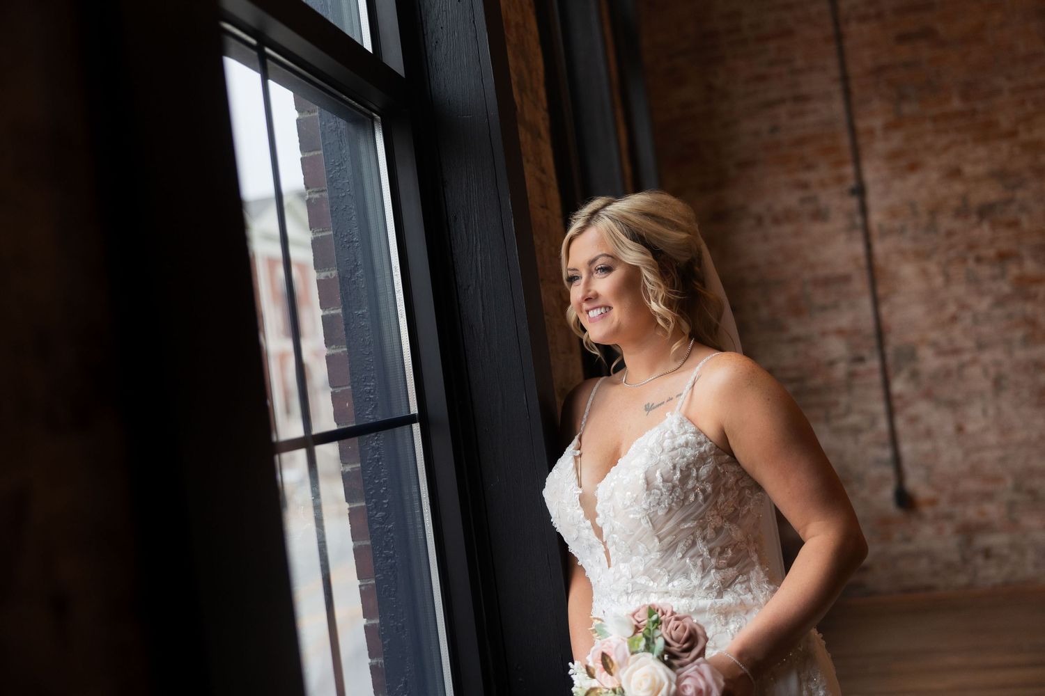 Elegant wedding photos in a rustic brick-walled venue with natural window light streaming in.
