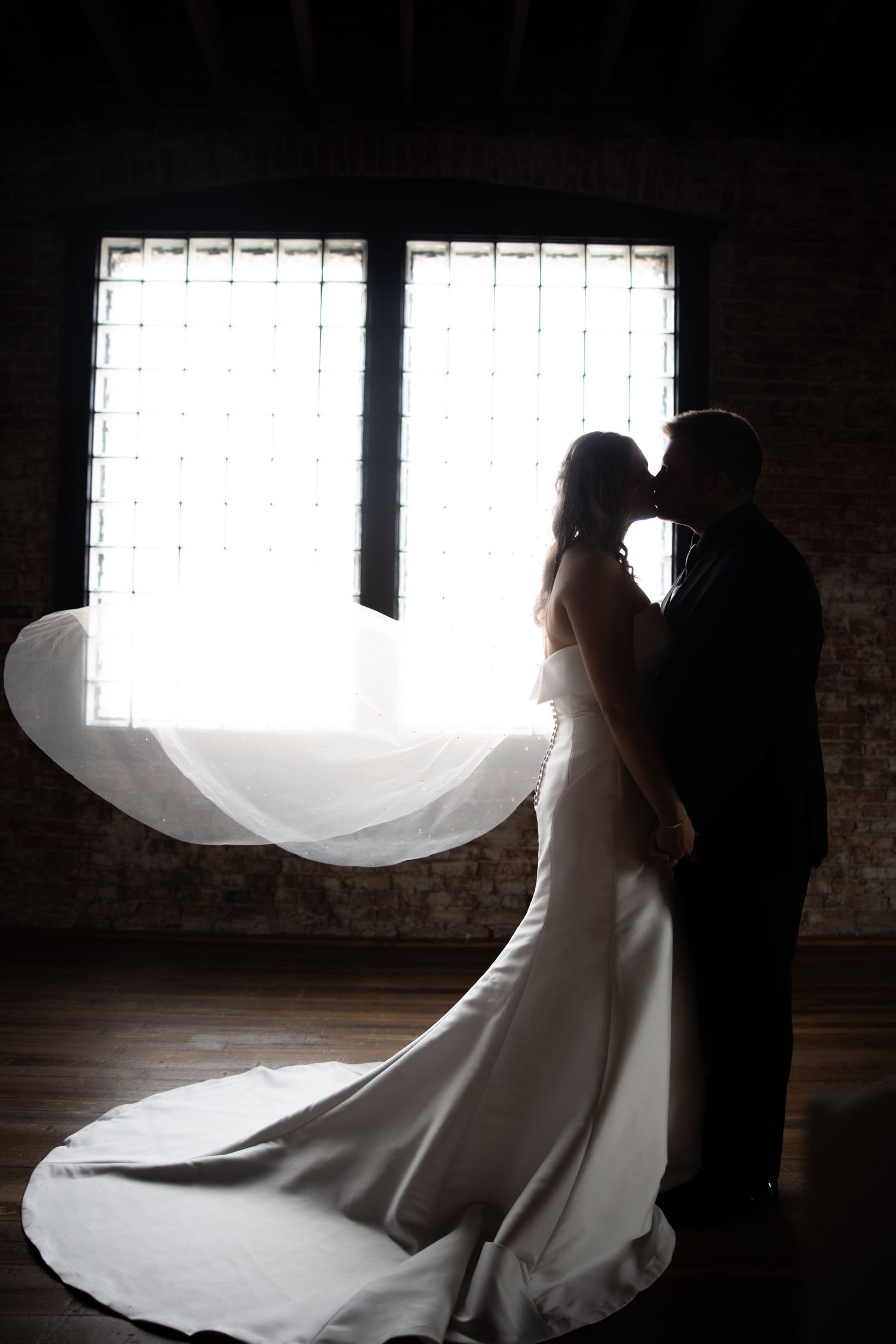 Silhouetted figures in dramatic backlit window scene.