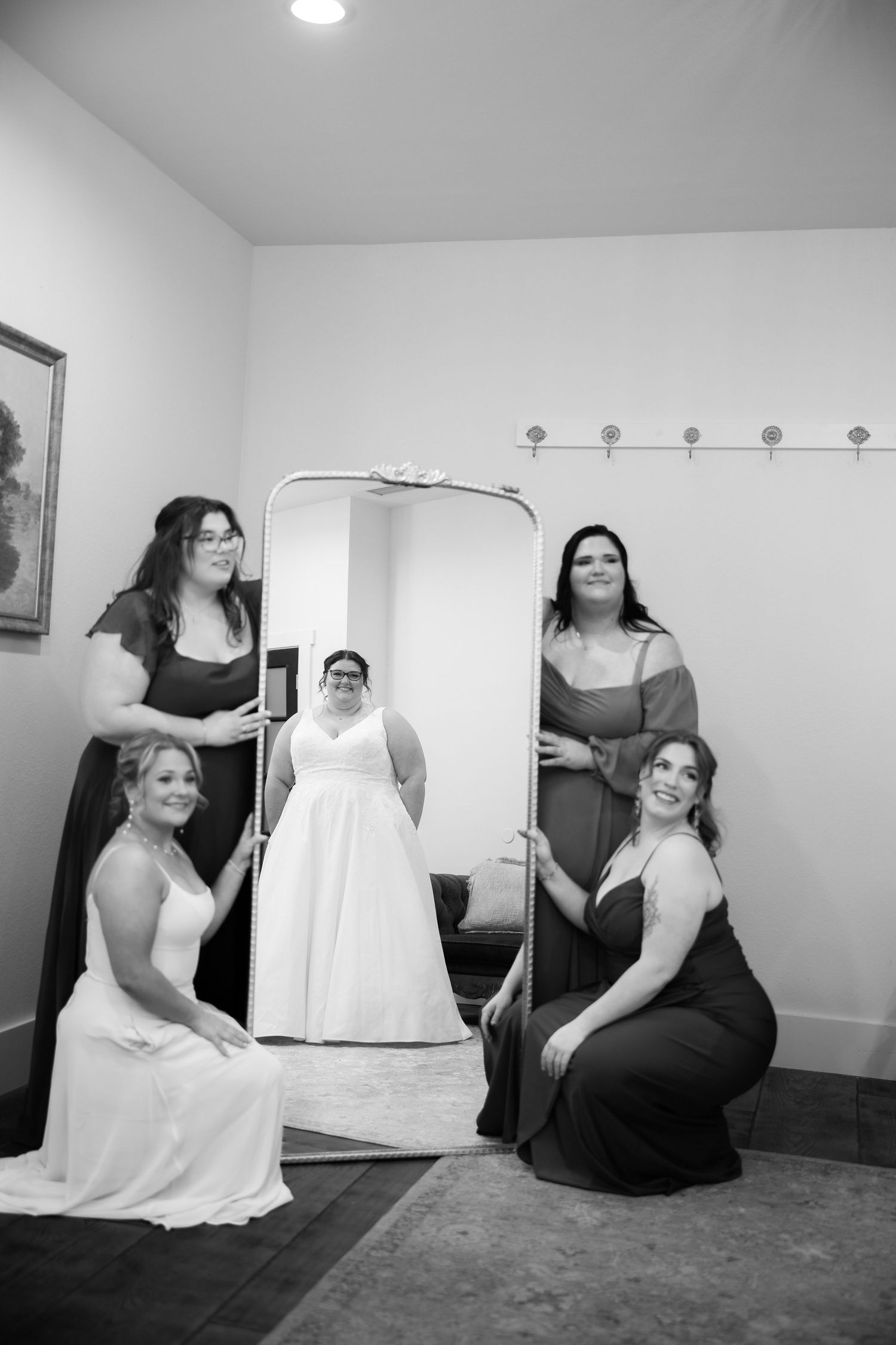 A series of black and white photos showing people posing with a white dress form in an interior space.