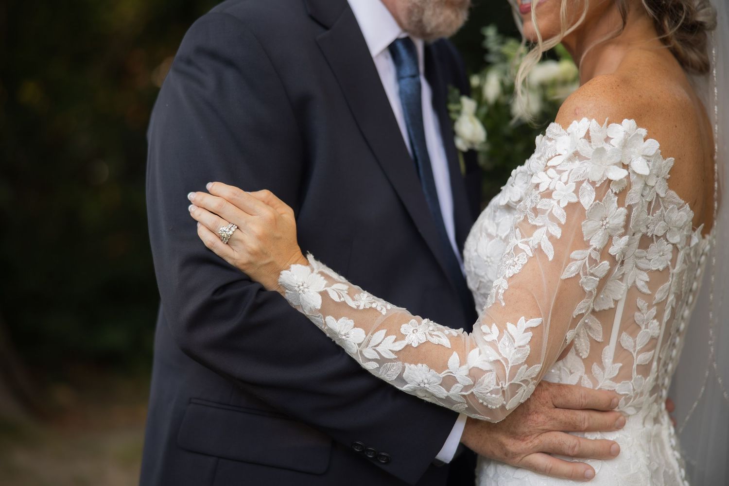 Romantic wedding portrait with lace details and intimate embrace.