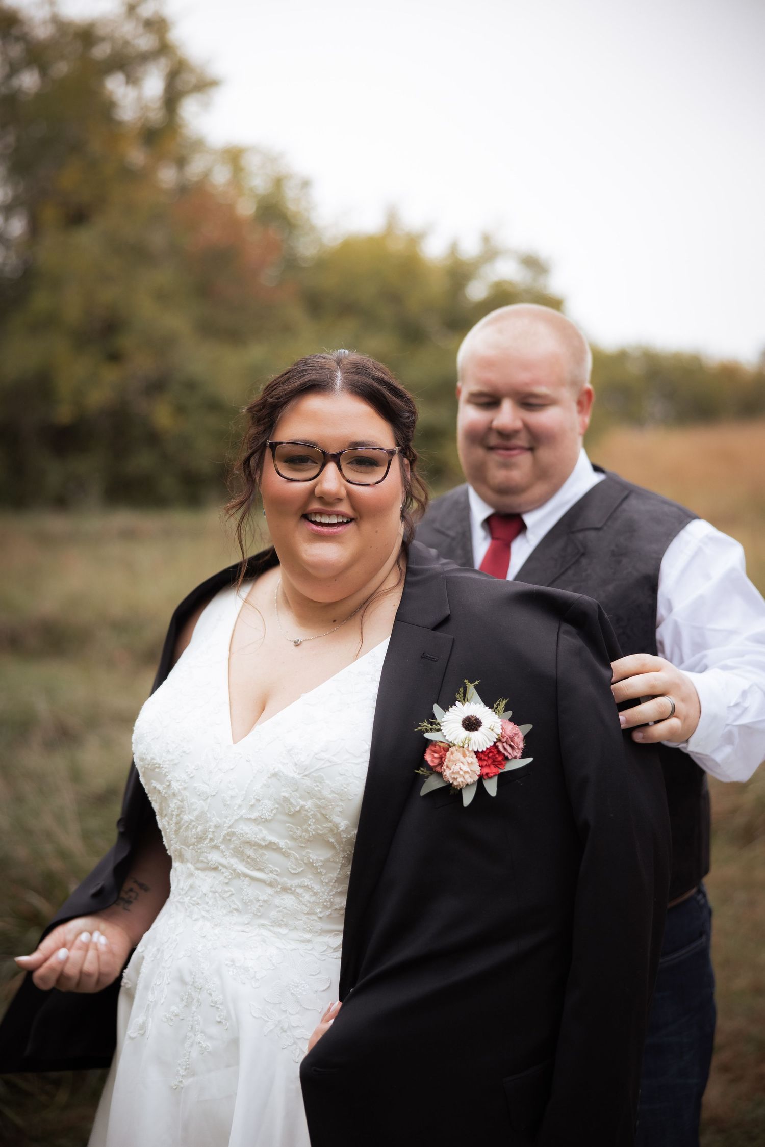 A happy couple shares candid moments during their autumn wedding photo session in an outdoor setting.