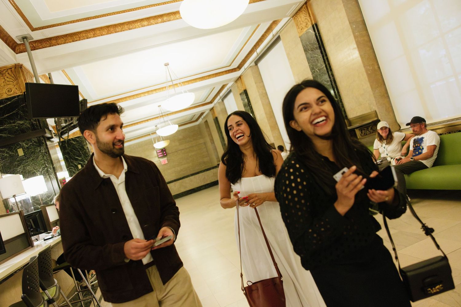 People enjoying drinks and socializing at a casual gathering in an indoor setting.