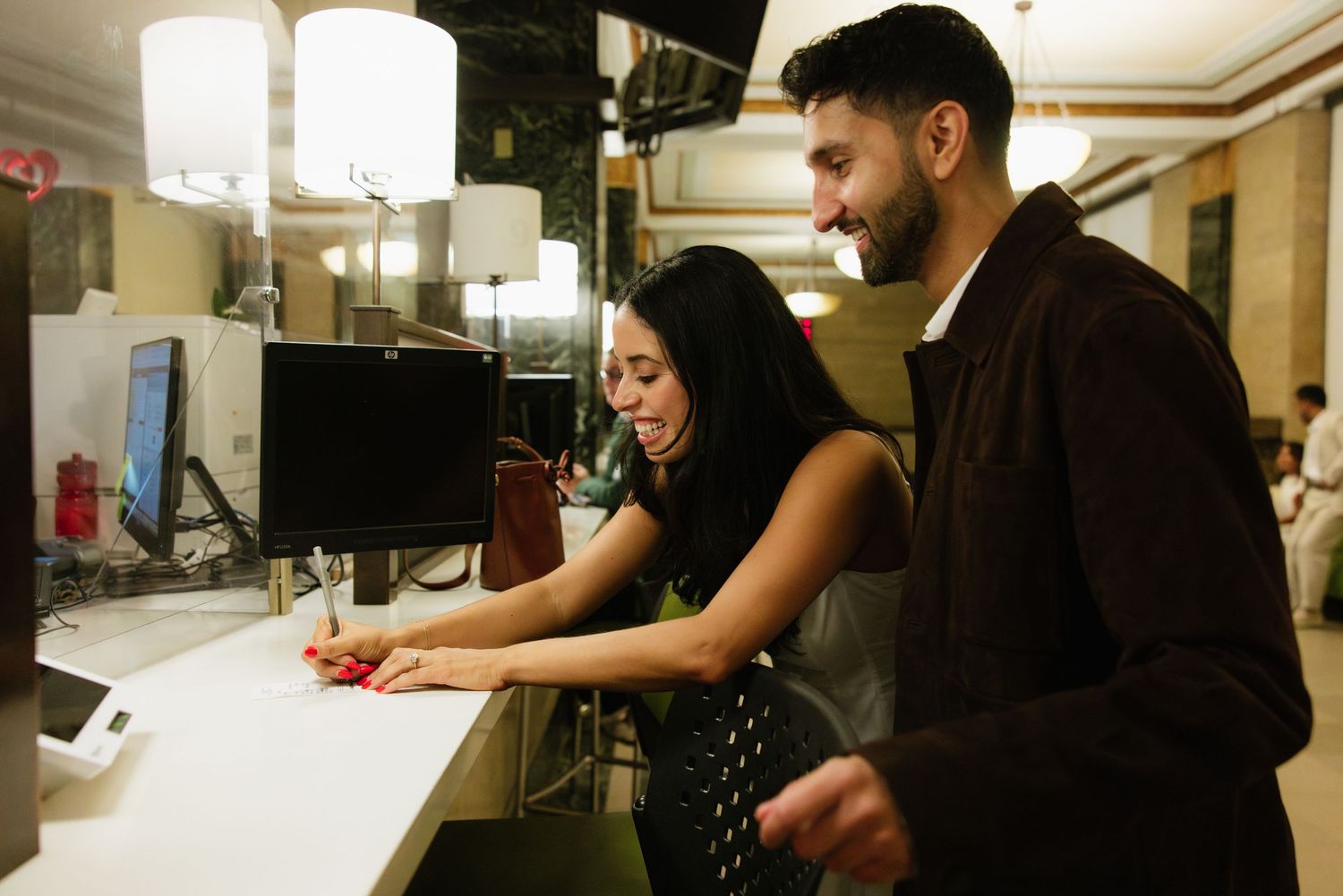 People working together at a long white counter in what appears to be a restaurant or commercial kitchen setting.