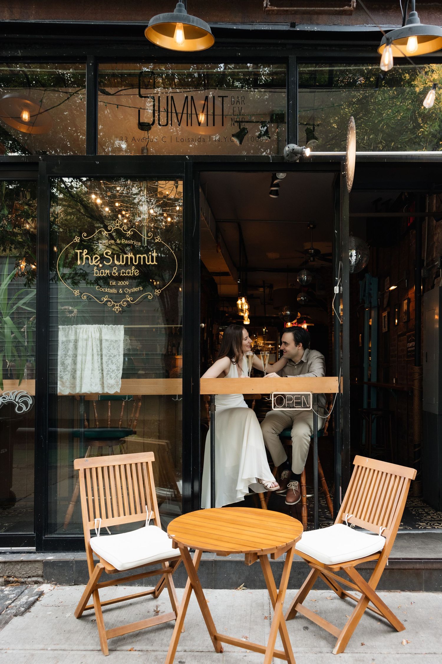 A cozy cafe storefront with wooden outdoor seating and 'The Summit' signage on glass windows at dusk.