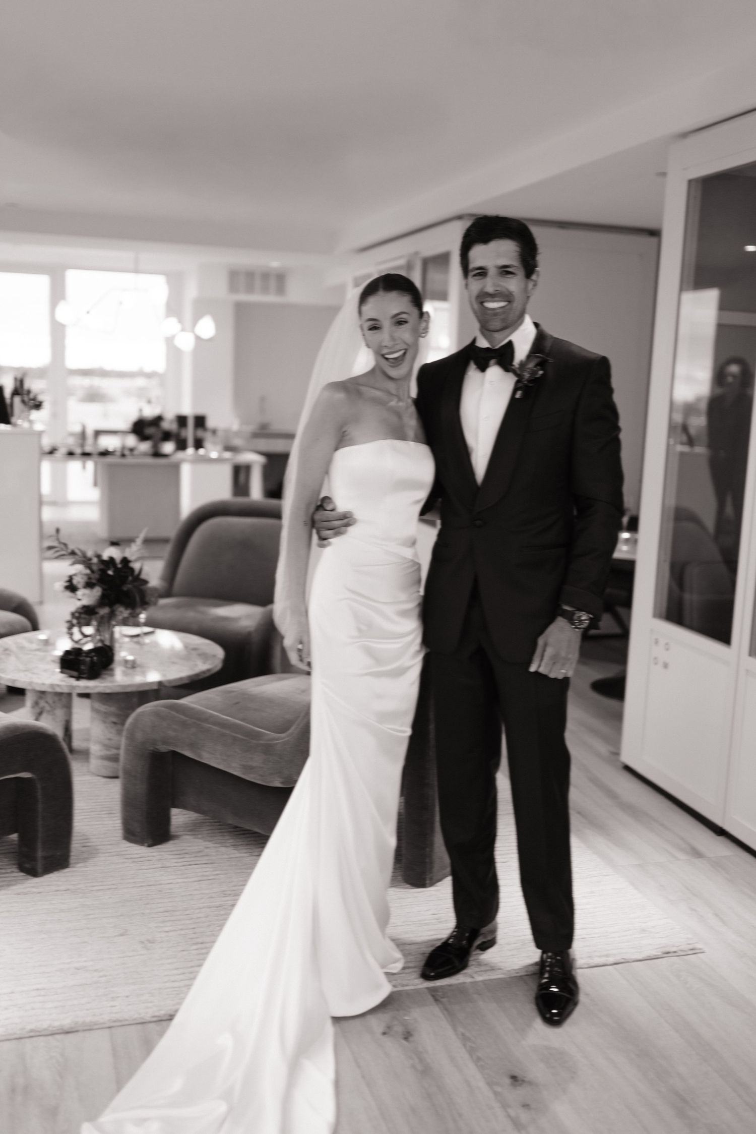 A bride and groom share candid moments in a series of black and white wedding photos showing their joyful celebration.