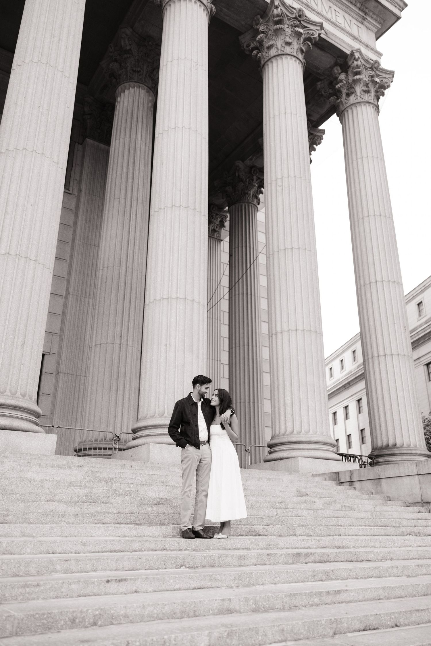 A black and white photo series showing a couple in formal attire posing on grand stone steps with classical columns.