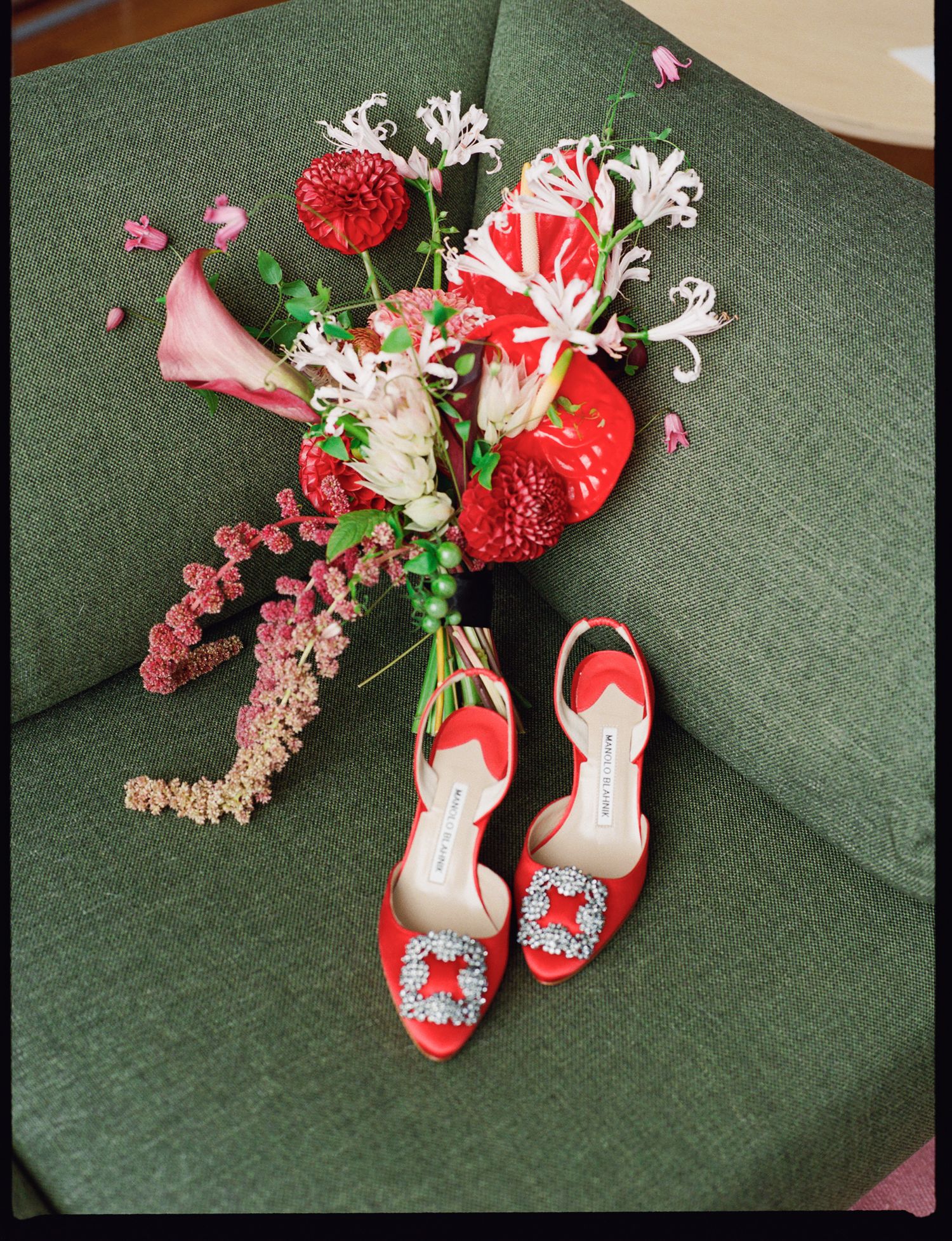 Decorative red floral ornaments and pink cherry blossoms arranged on a dark green textured surface.