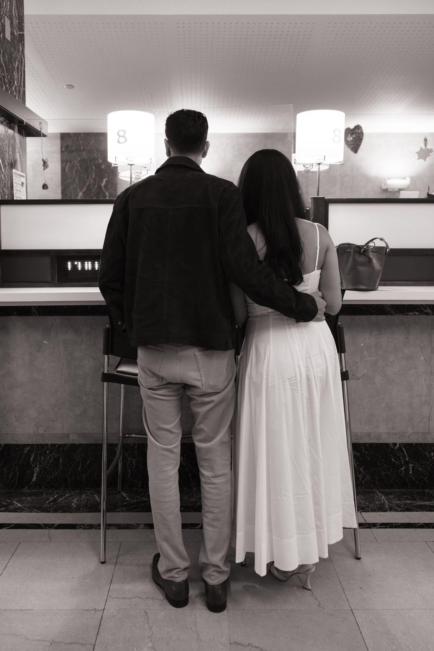 A black and white photo sequence showing a couple in formal attire standing at a counter or bar.