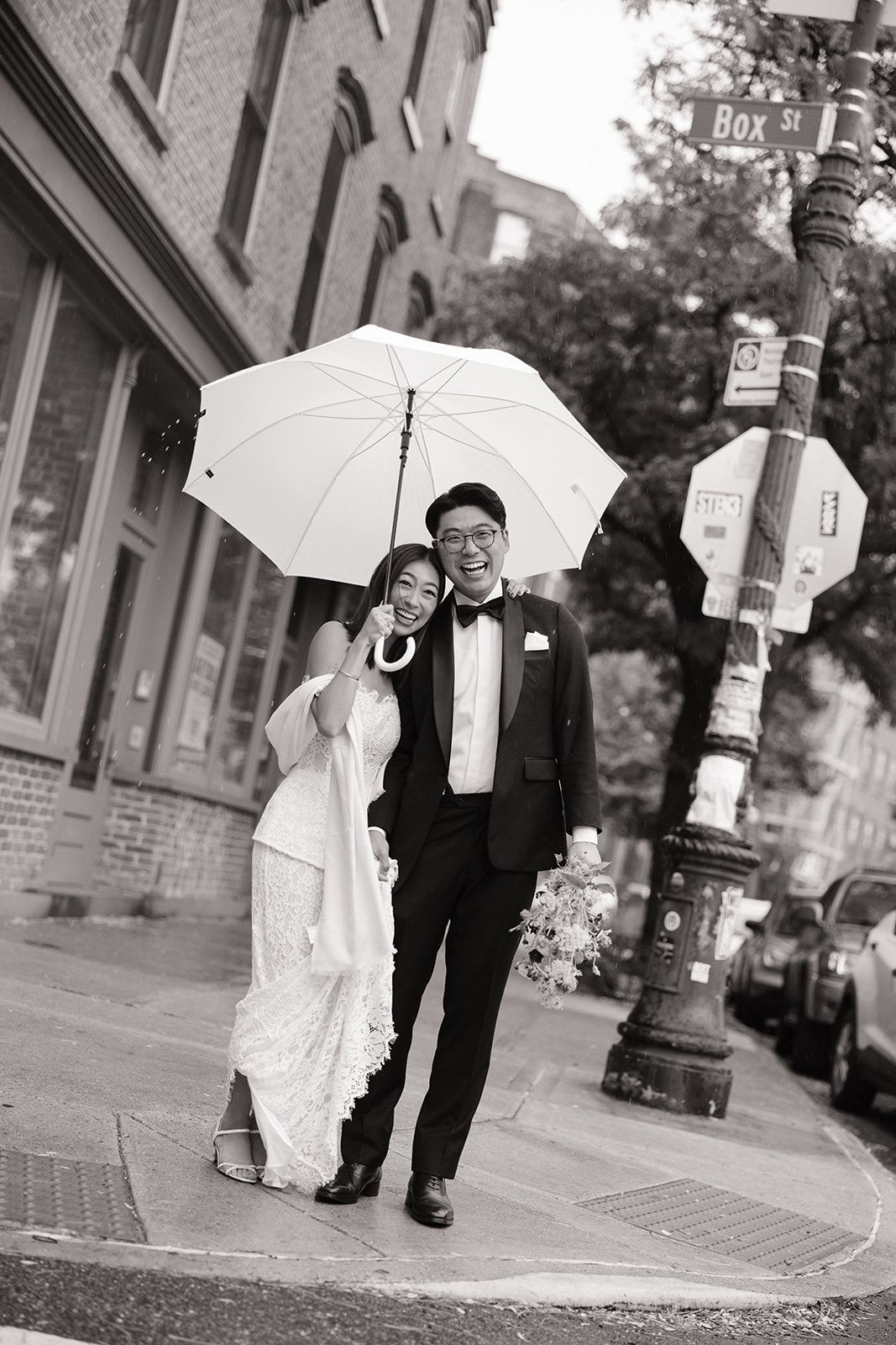A wedding couple shares an umbrella while walking down a brick sidewalk in a series of black and white photos.