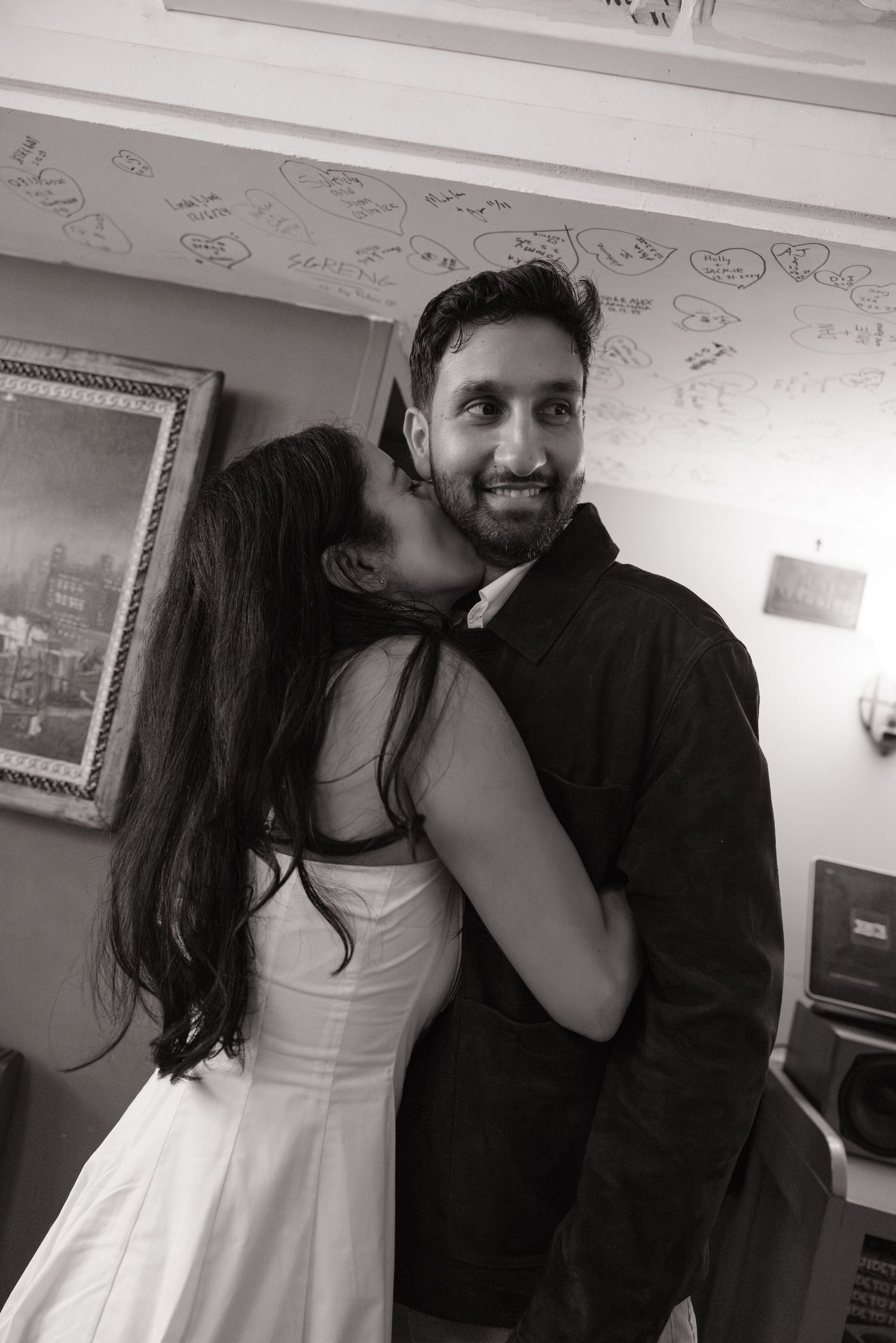 A couple shares a playful moment together in a series of black and white candid photos.