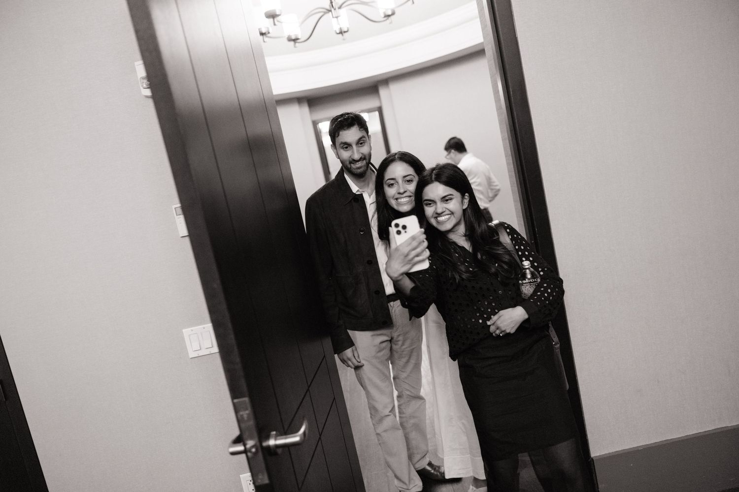 A series of black and white elevator photos showing playful interactions between people in a casual setting.