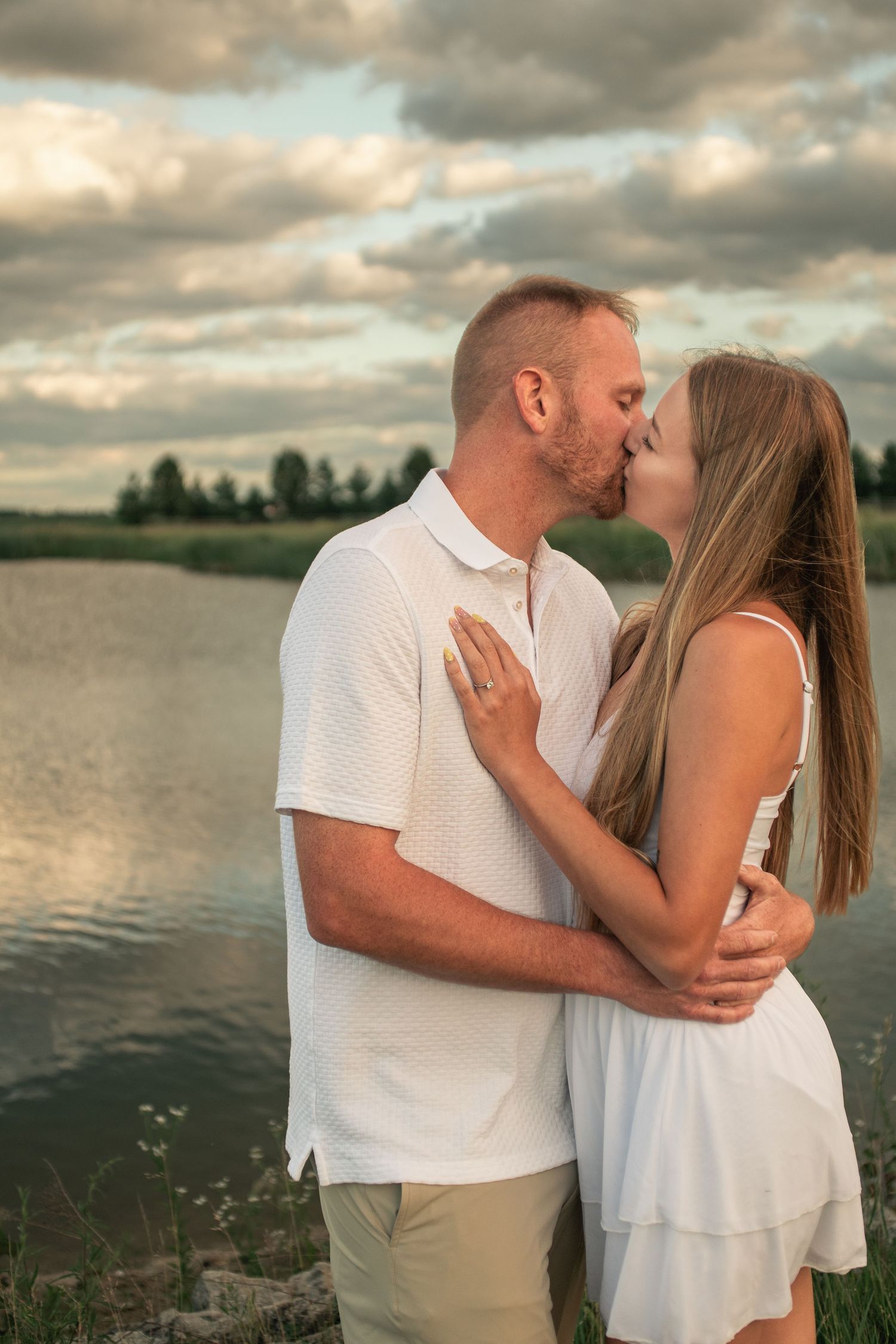 Golden hour engagement session portrait with ring focus in front of pond at Willow Creek Farm in Urbana IL by Urbana Ever After Photography