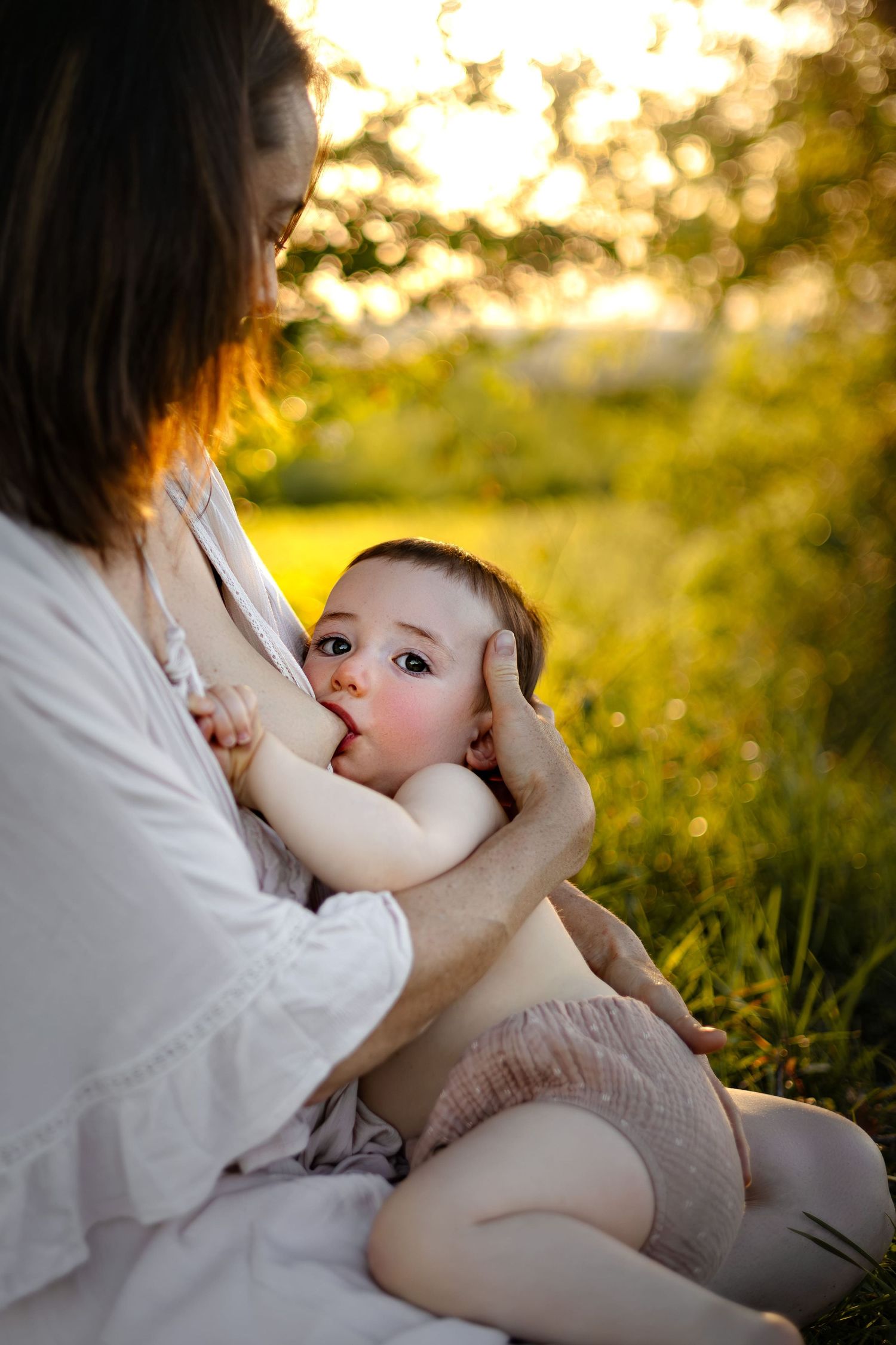 Bébé allaité par sa maman dans un lieu naturel au coucher du soleil. Séance photo maternité en extérieur à Langon, La Réole Sud Gironde