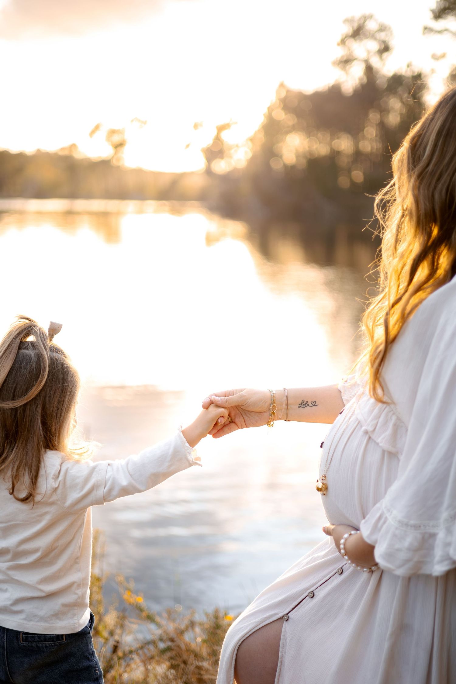 Maman enceinte qui tient la main de sa première fille.
Séance photo grossesse en extérieur à Langon, La Réole Bazas Sud gironde