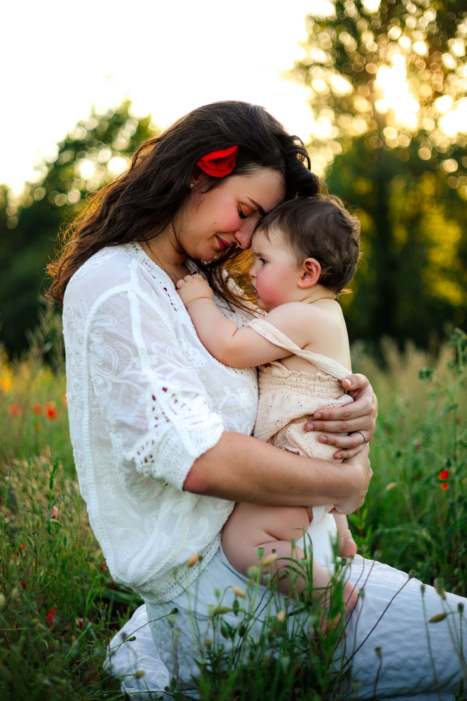 Maman complice avec sa fille dans un champs de coquelicots au coucher du soleil. Séance photo maternité en extérieur à Langon, Sud Gironde