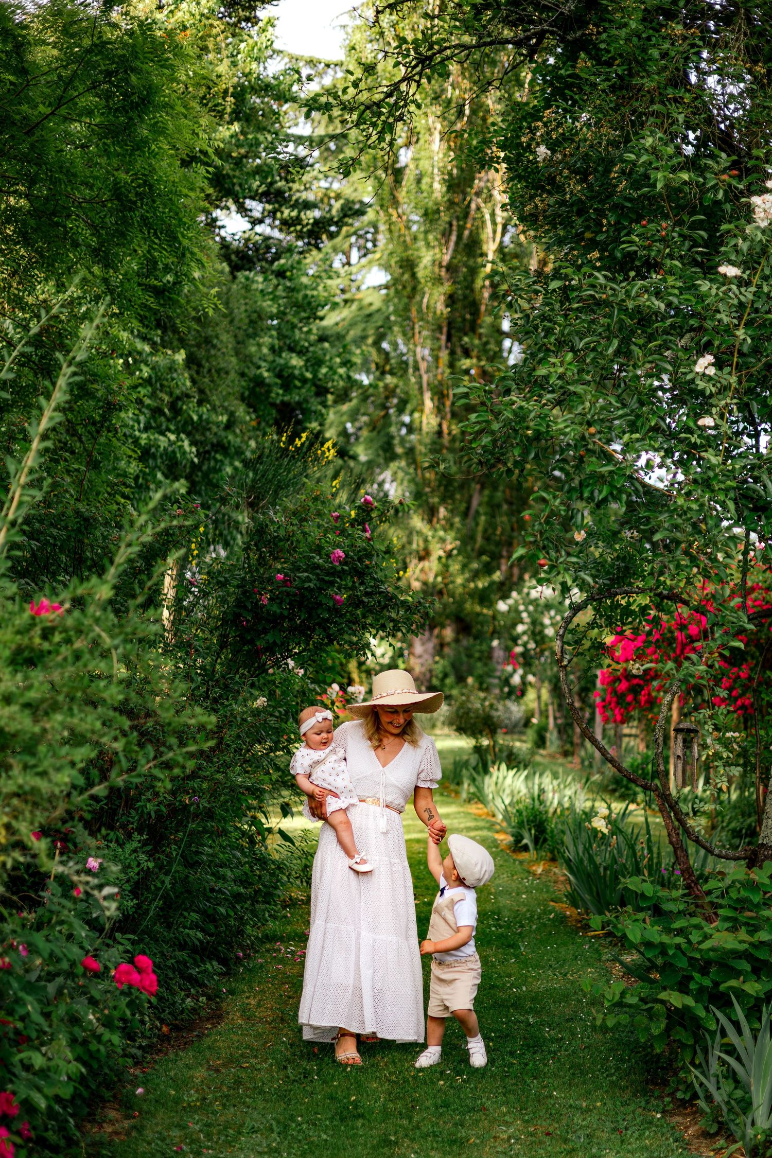 Maman et ses enfants dans un jardin fleuri. Séance photo maternité en extérieur à La Réole, Sud Gironde