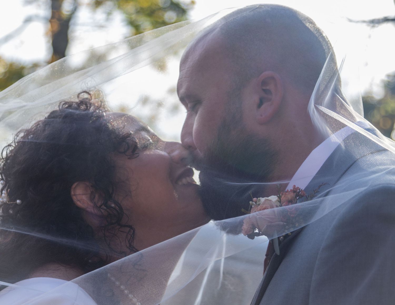 A romantic wedding moment captured through a soft-focus lens in natural outdoor lighting.