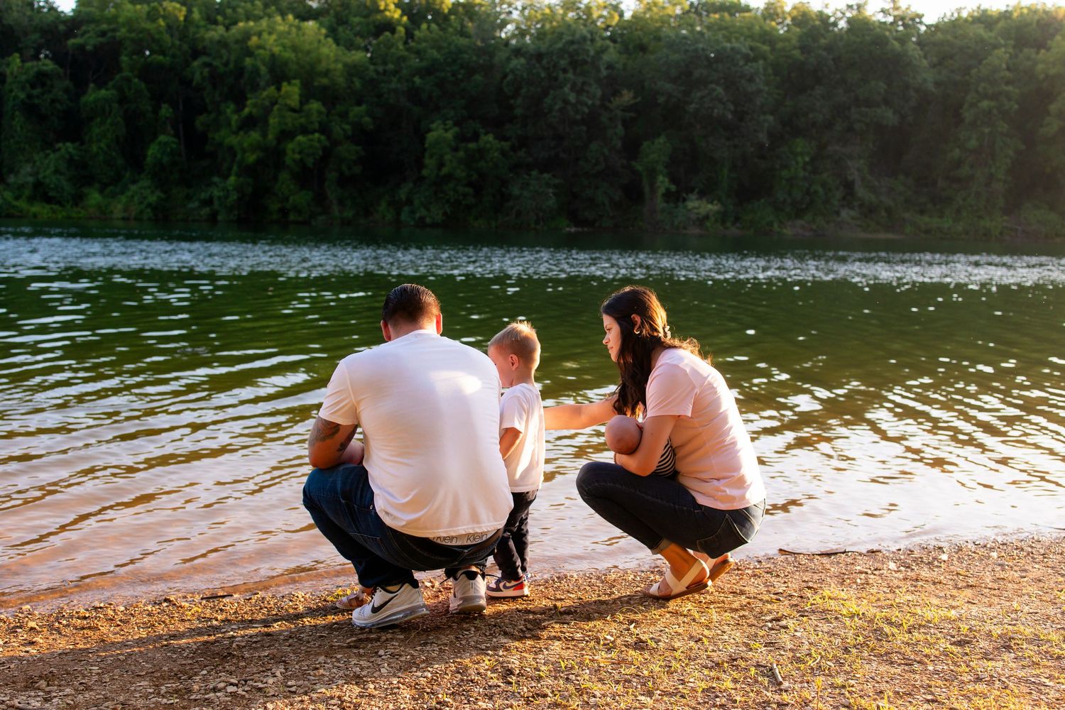 Couple relaxing by a peaceful lake at sunset.