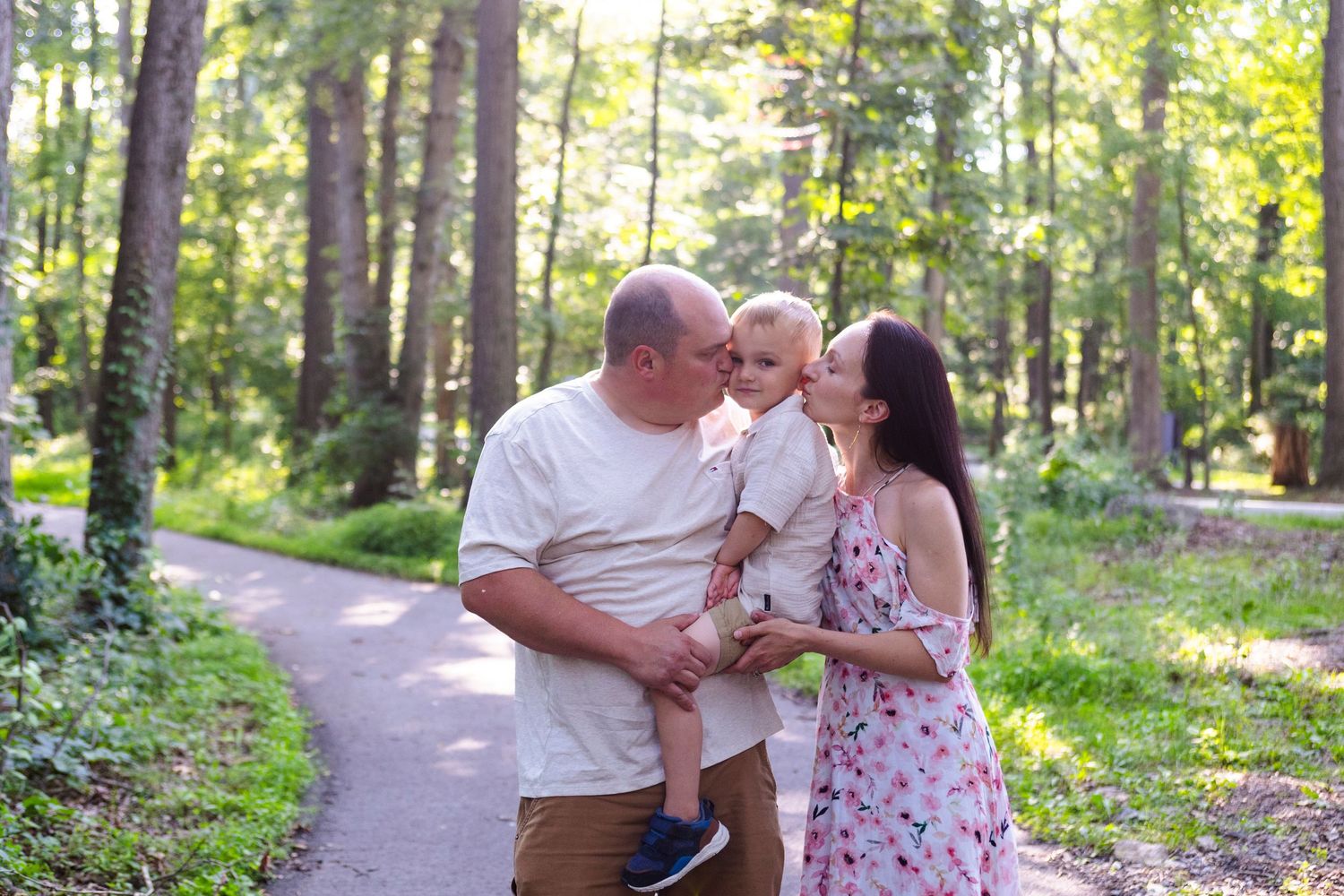 Family enjoying a sunny day together on a forest trail.