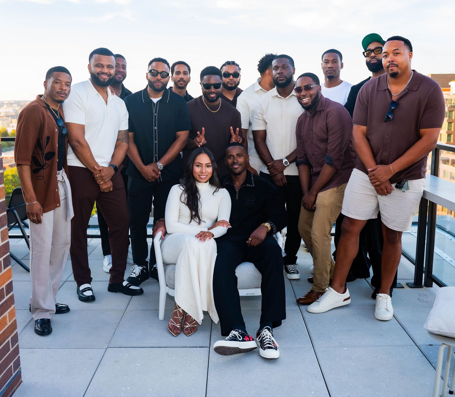 A group photo of friends gathered on a rooftop terrace for a special occasion.