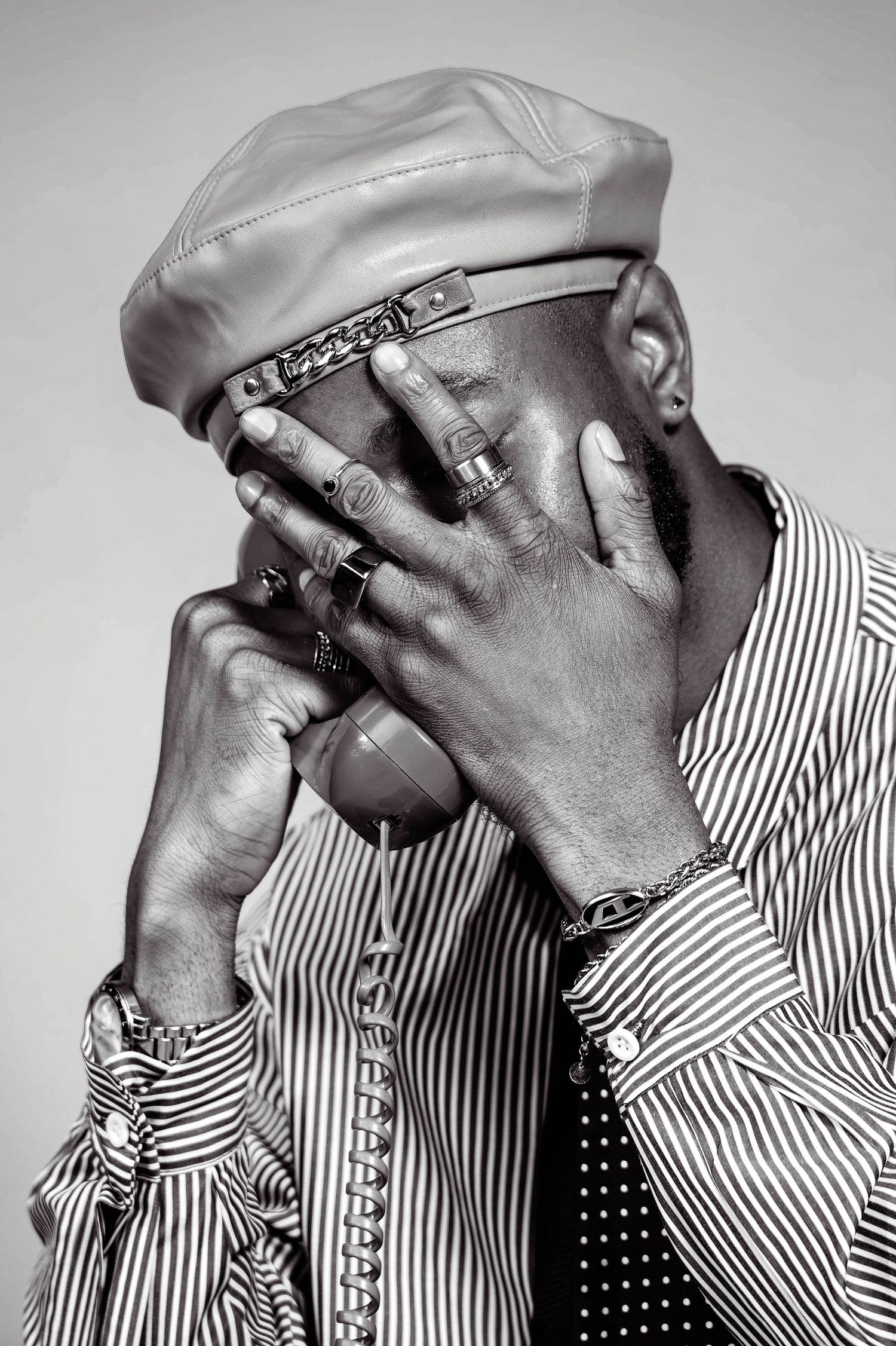 A series of black and white photos showing someone in a striped shirt covering their face with their hands.
