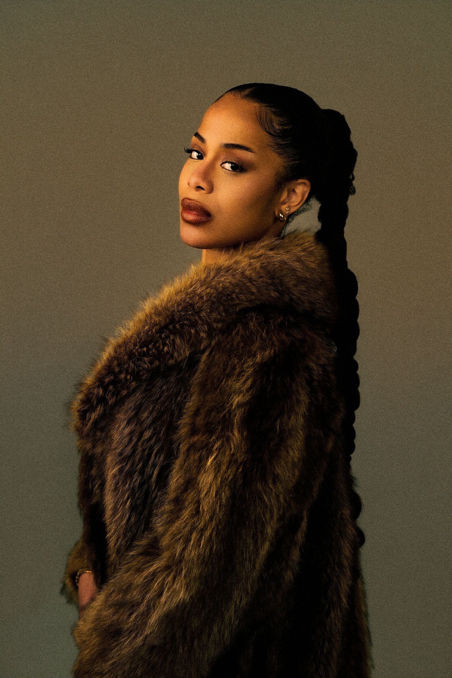 Glamour portrait series featuring a brown fur wrap against a neutral backdrop.