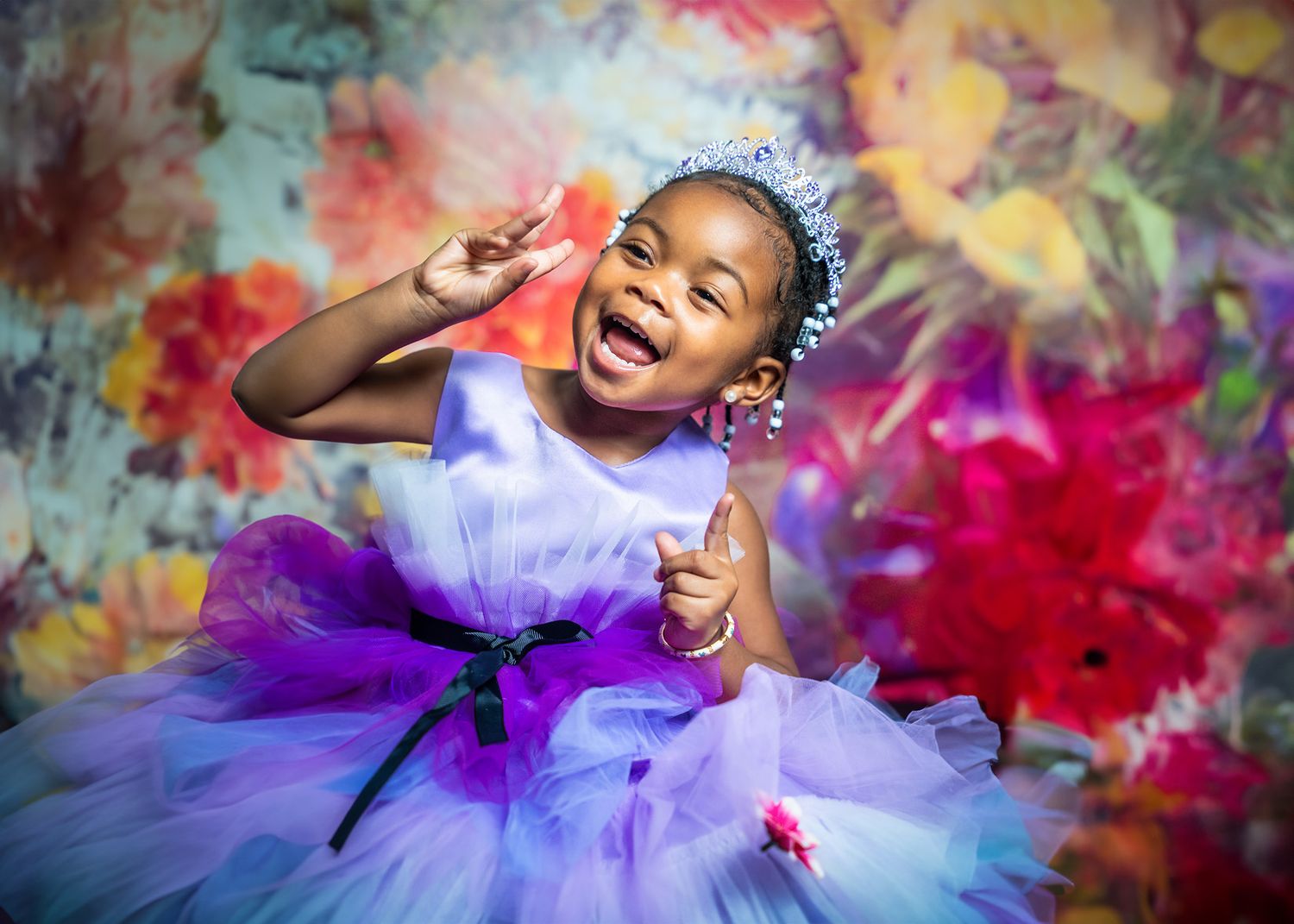 Joyful dancer in purple tutu twirls against colorful paint splash background.