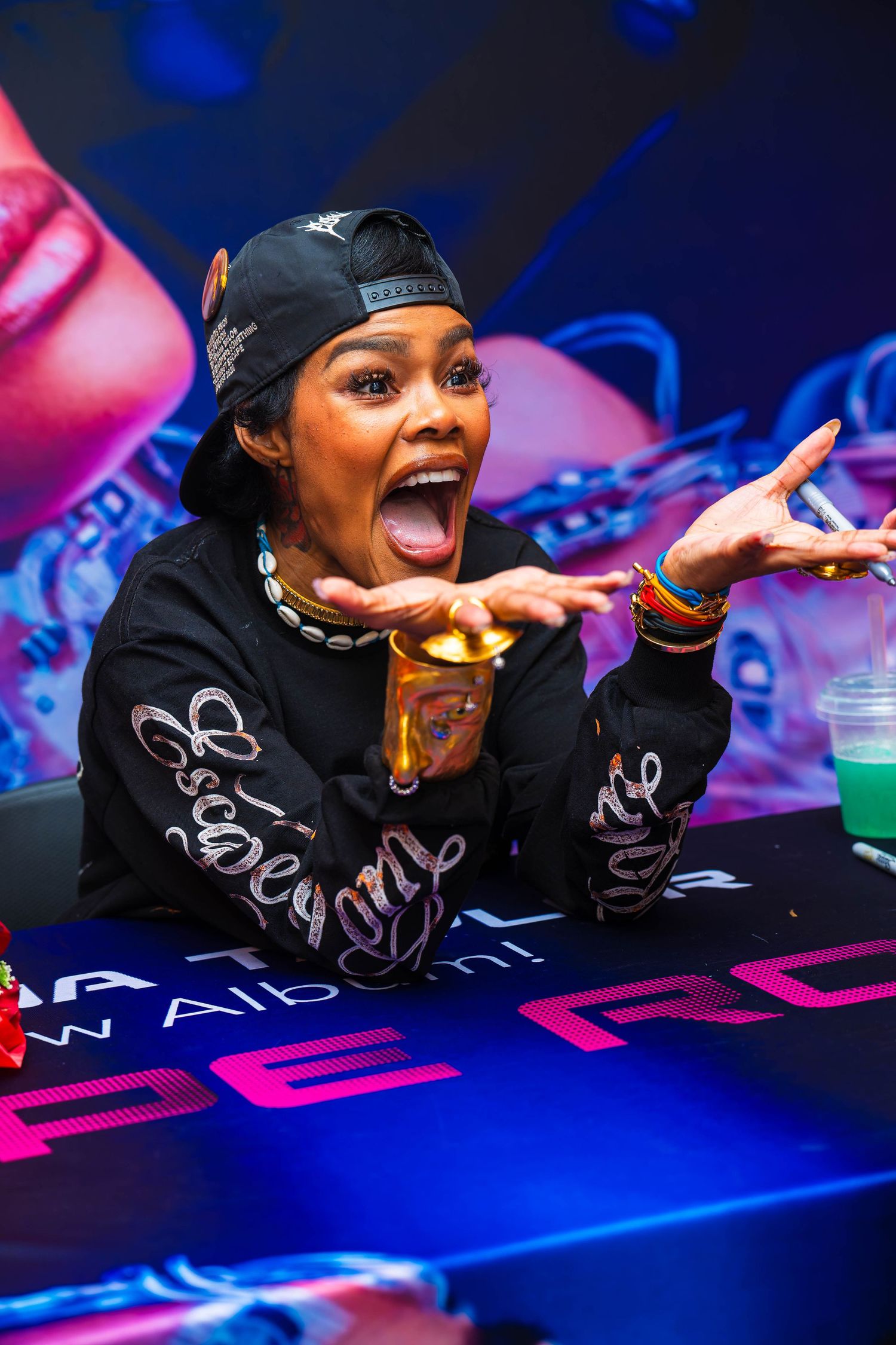 Close-up shots of performer in black attire against vibrant blue and pink lighting.
