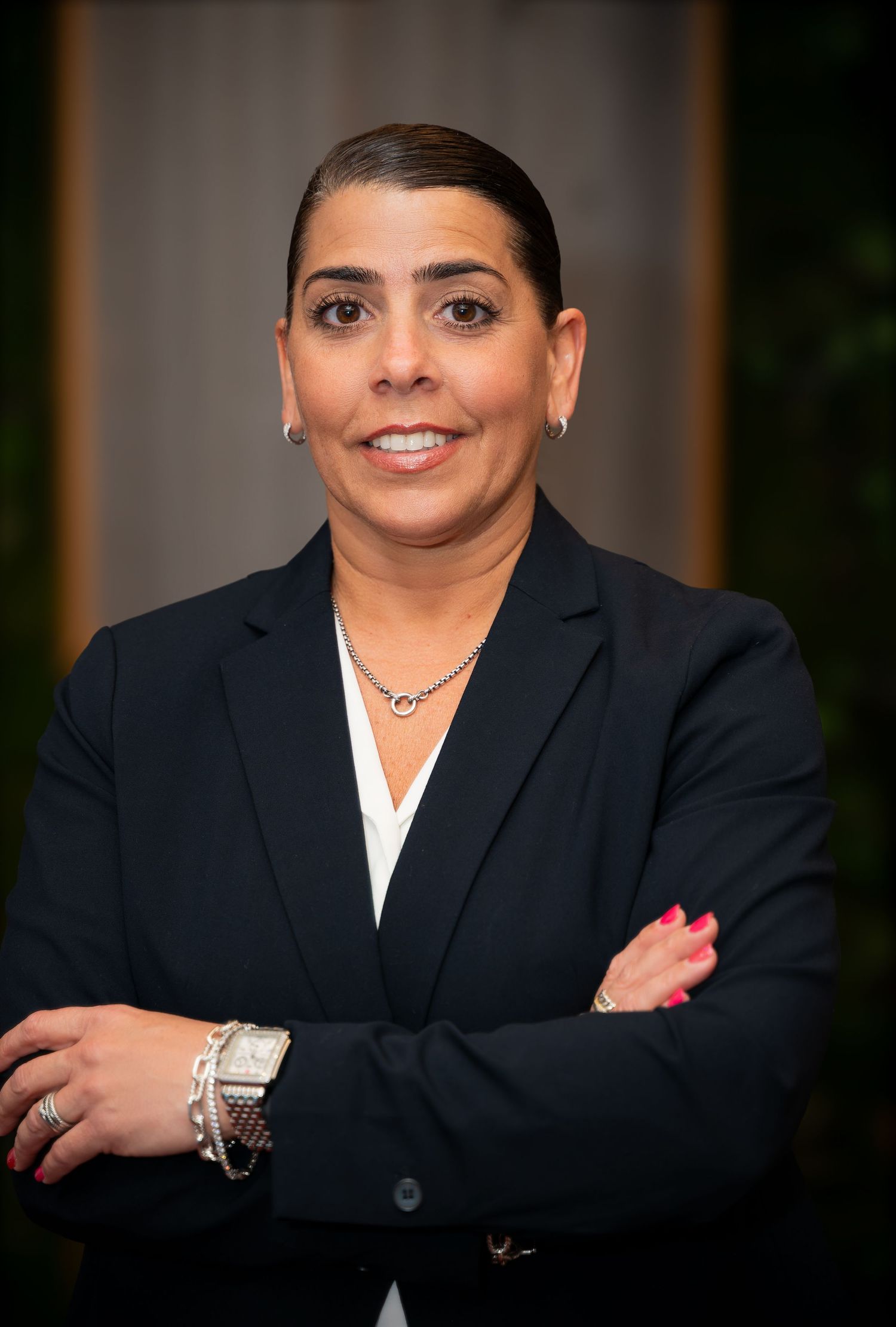 Professional headshots of person in dark business suit against studio backdrop.