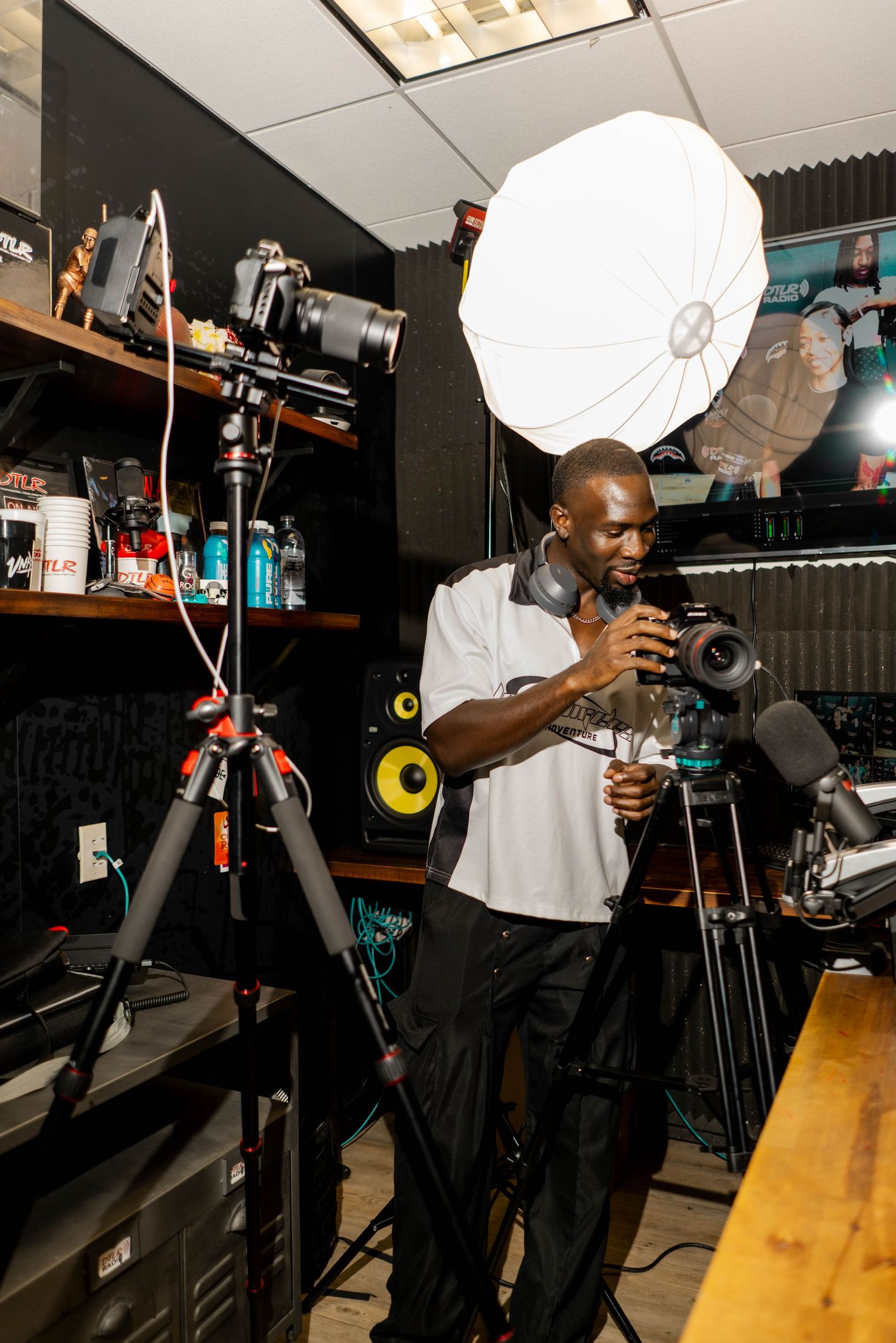 Professional photo shoot setup with lighting equipment and camera gear in dark studio.