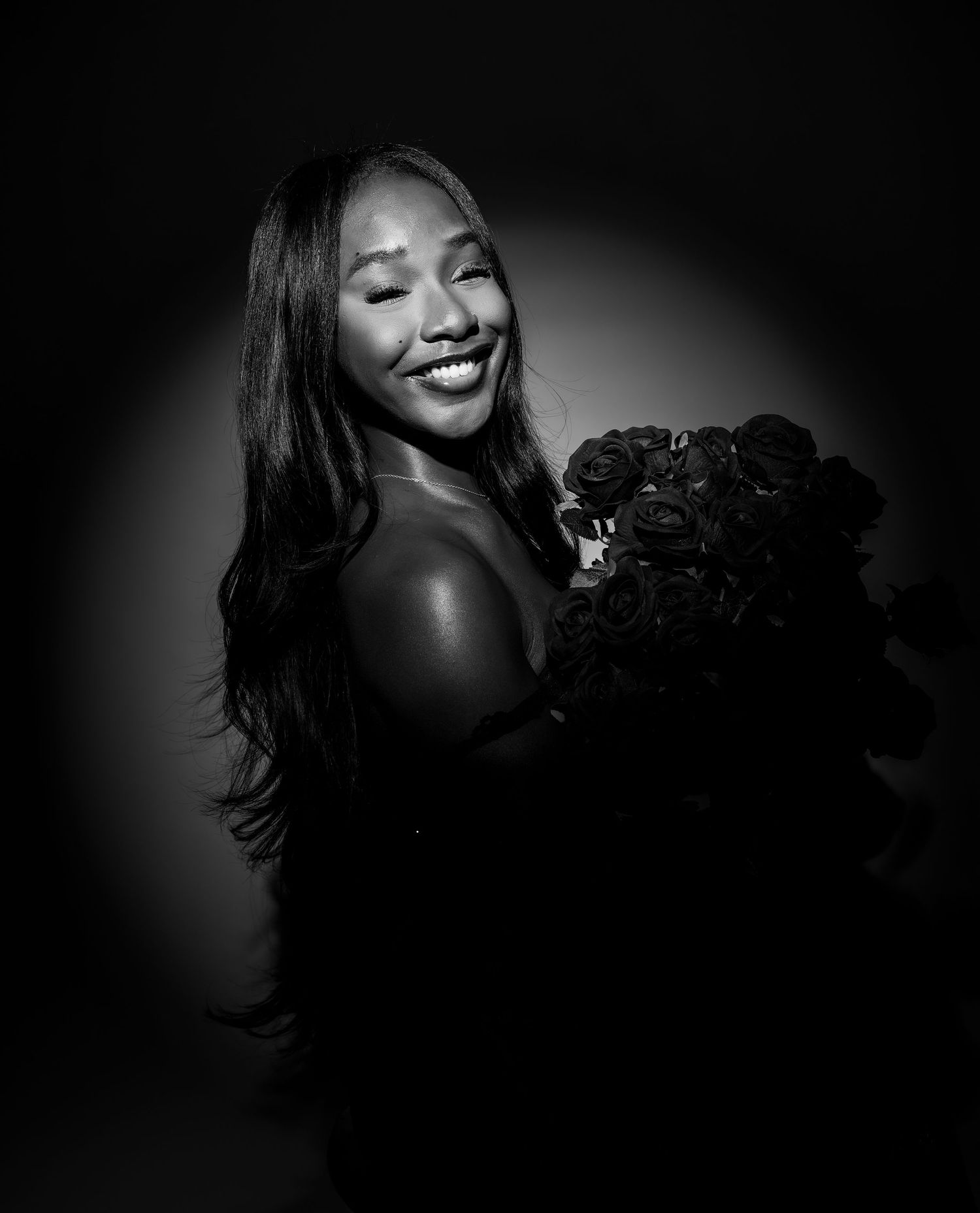 A dramatic black and white portrait series showing joyful expressions and laughter against a dark background.