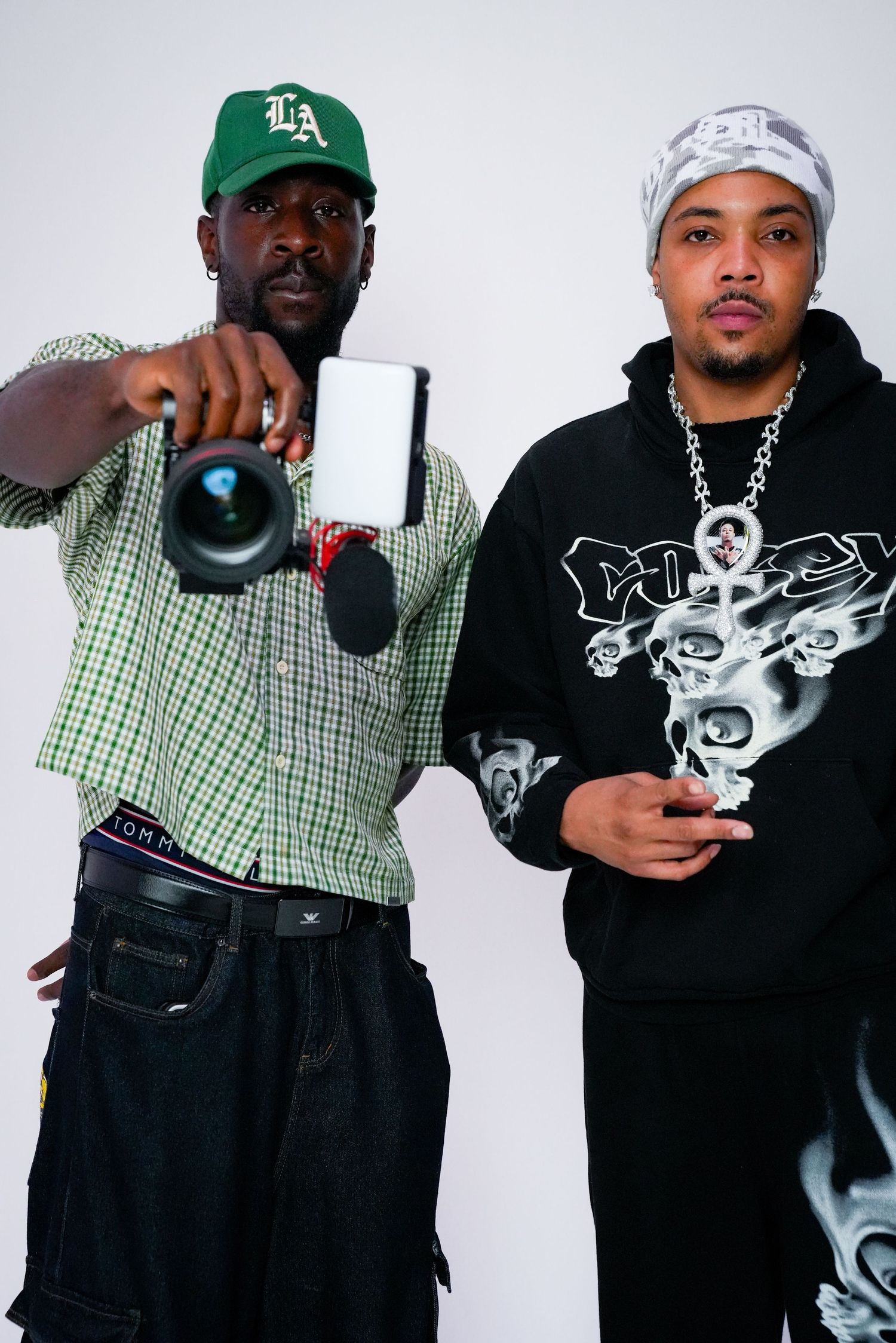 Group wearing casual streetwear and baseball caps posing together in studio.