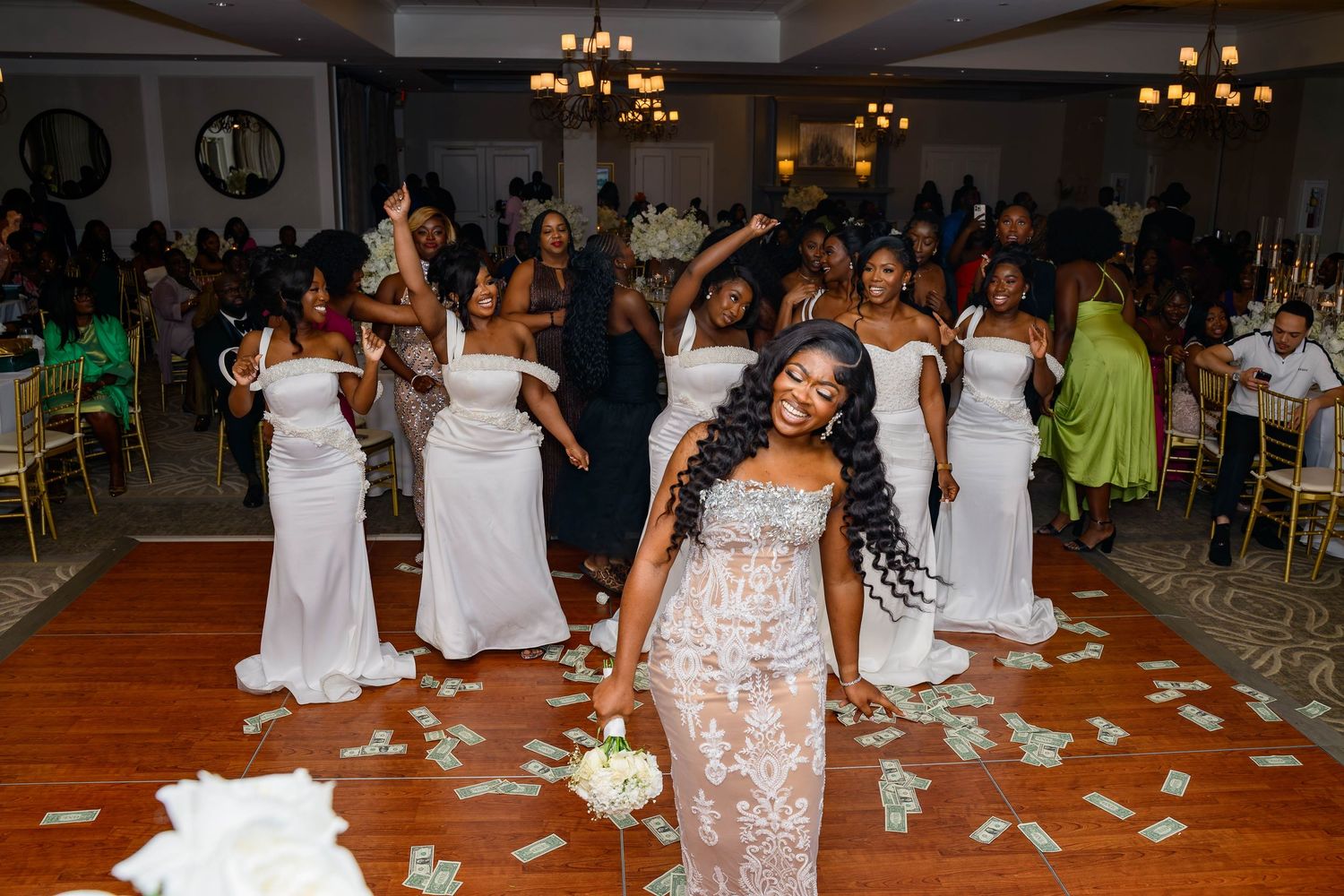 Wedding celebration scene with dancing and flower petals scattered on the dance floor.