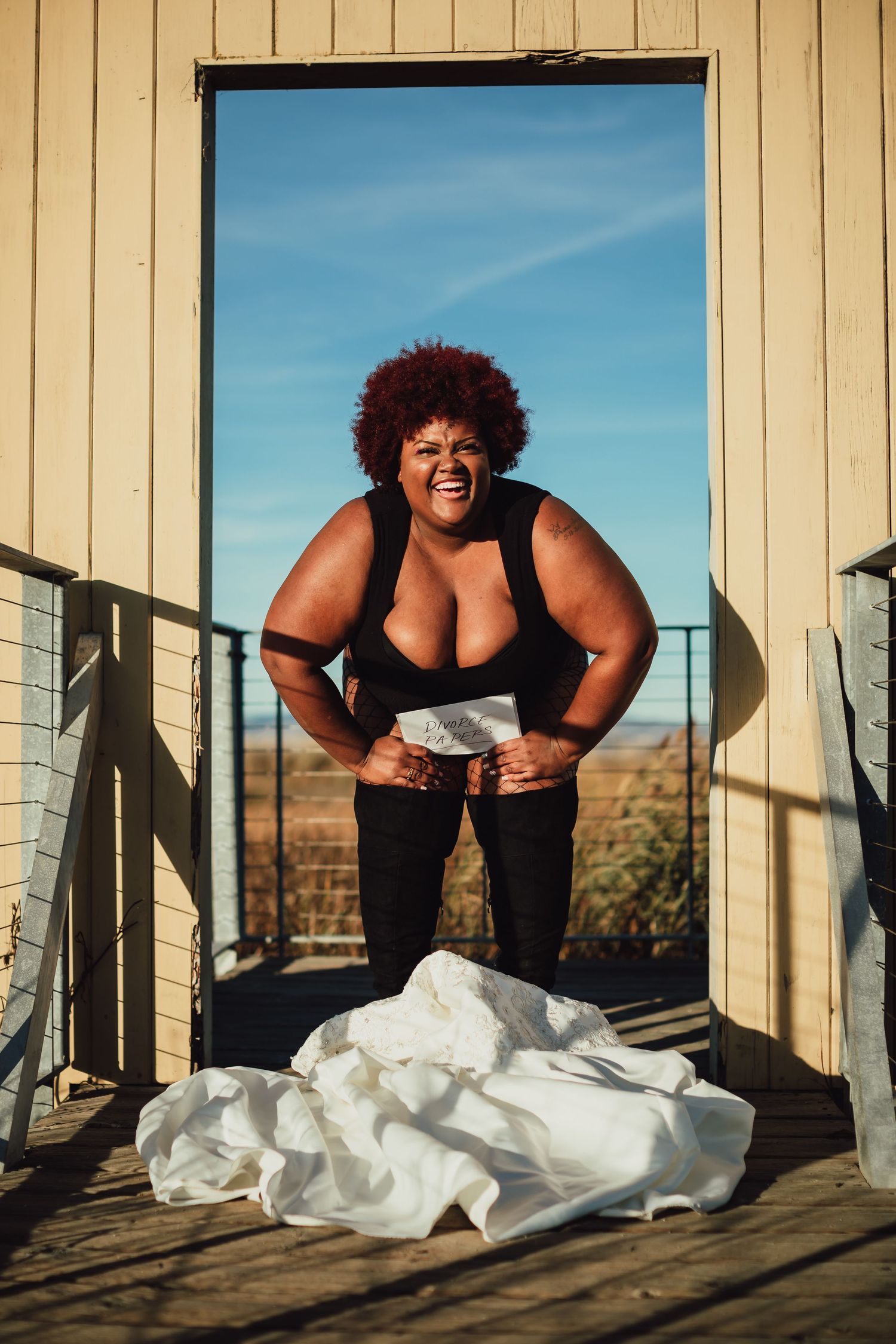 Artistic portrait session with white fabric on wooden deck during golden hour.