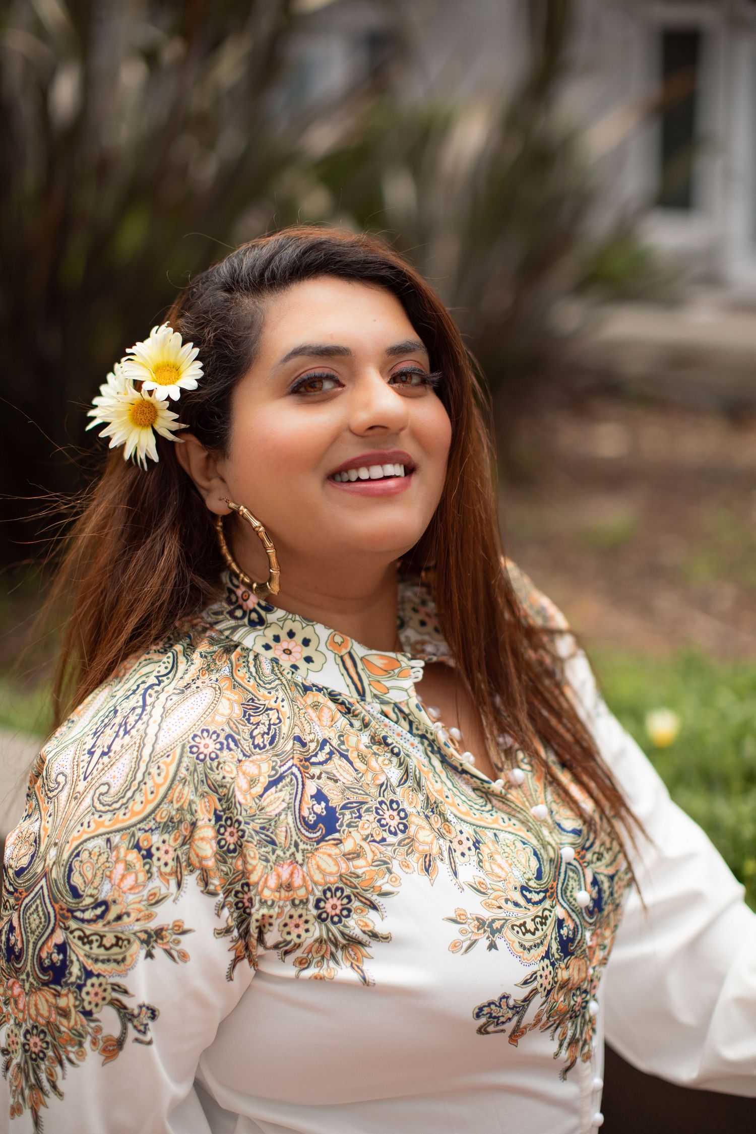 Spring fashion portrait with white embroidered top and daisy flower hair accessory.